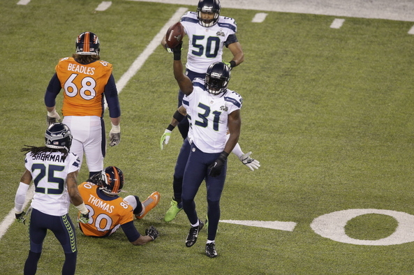 Seattle Seahawks' Kam Chancellor (31) celebrates with teammates Richard Sherman (25) and K.J. Wright (50) after intercepting a pass to Denver Broncos' Julius Thomas (80) during the first half of the NFL Super Bowl XLVIII football game Sunday, Feb. 2, 2014, in East Rutherford, N.J. (AP Photo/Charlie Riedel)