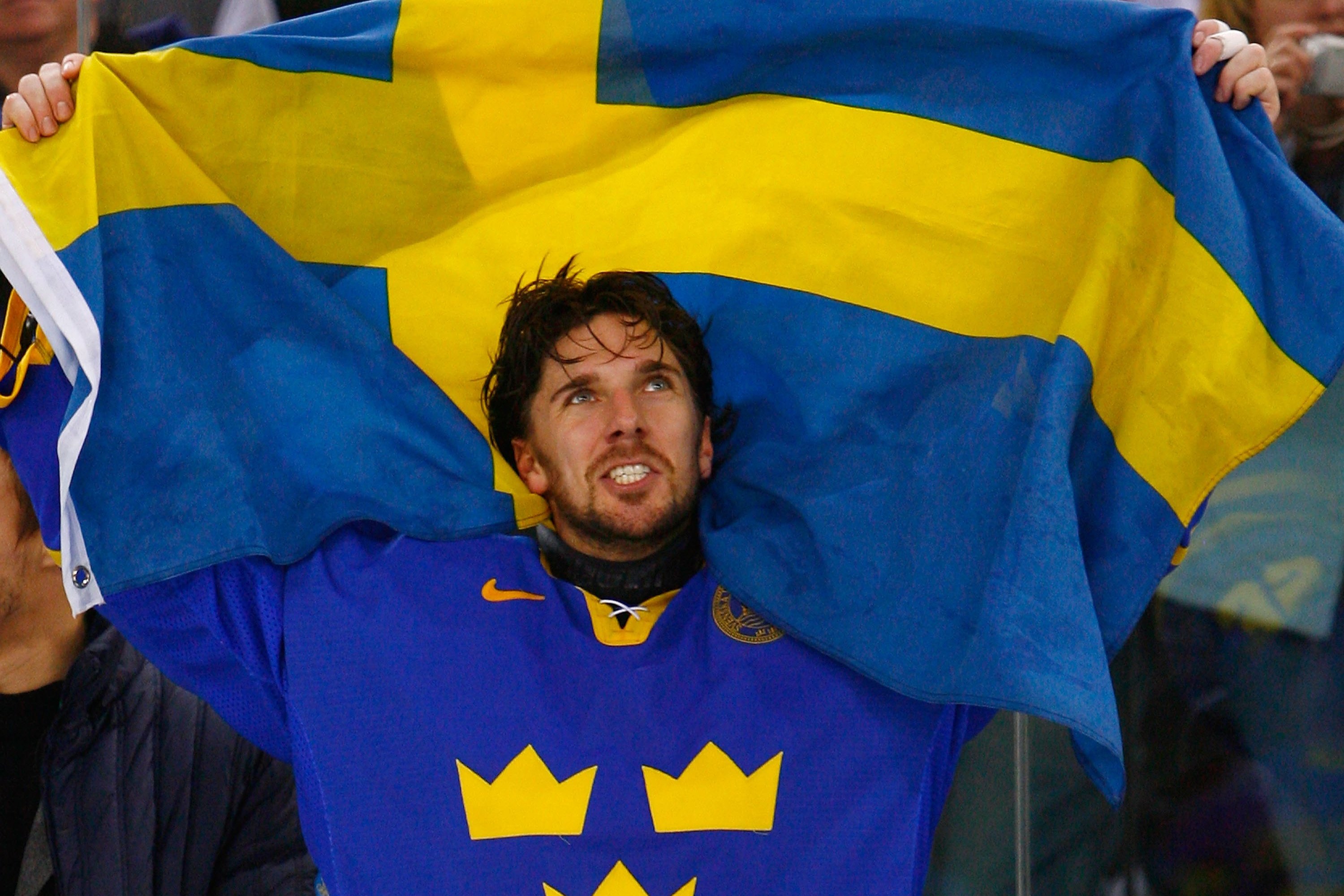 TURIN, ITALY - FEBRUARY 26:  Henrik Lundqvist #35 of Sweden waves the Swedish flag after Sweden defeated Finland 3-2 to win the gold medal during the final of the men's ice hockey match between Finland and Sweden during Day 16 of the Turin 2006 Winter Olympic Games on February 26, 2006 at the Palasport Olimpico in Turin, Italy.  (Photo by Al Bello/Getty Images)