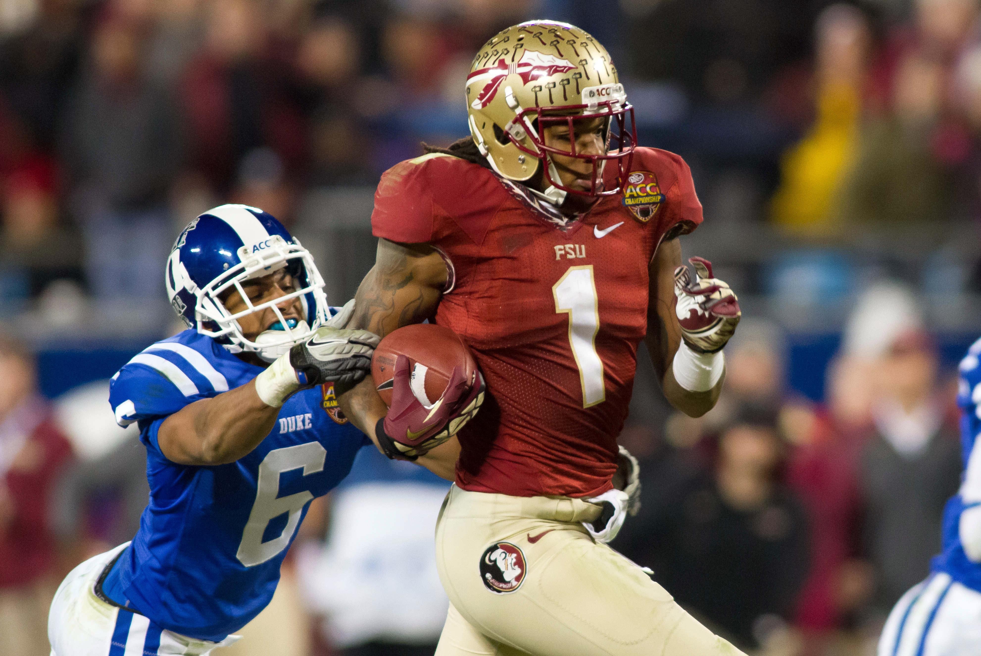 Dec 7, 2013; Charlotte, NC, USA; Florida State Seminoles wide receiver Kelvin Benjamin (1) runs by the tackle of Duke Blue Devils cornerback Ross Cockrell (6) during the third quarter at Bank of America Stadium. FSU defeated Duke 45-7. Mandatory Credit: Jeremy Brevard-USA TODAY Sports