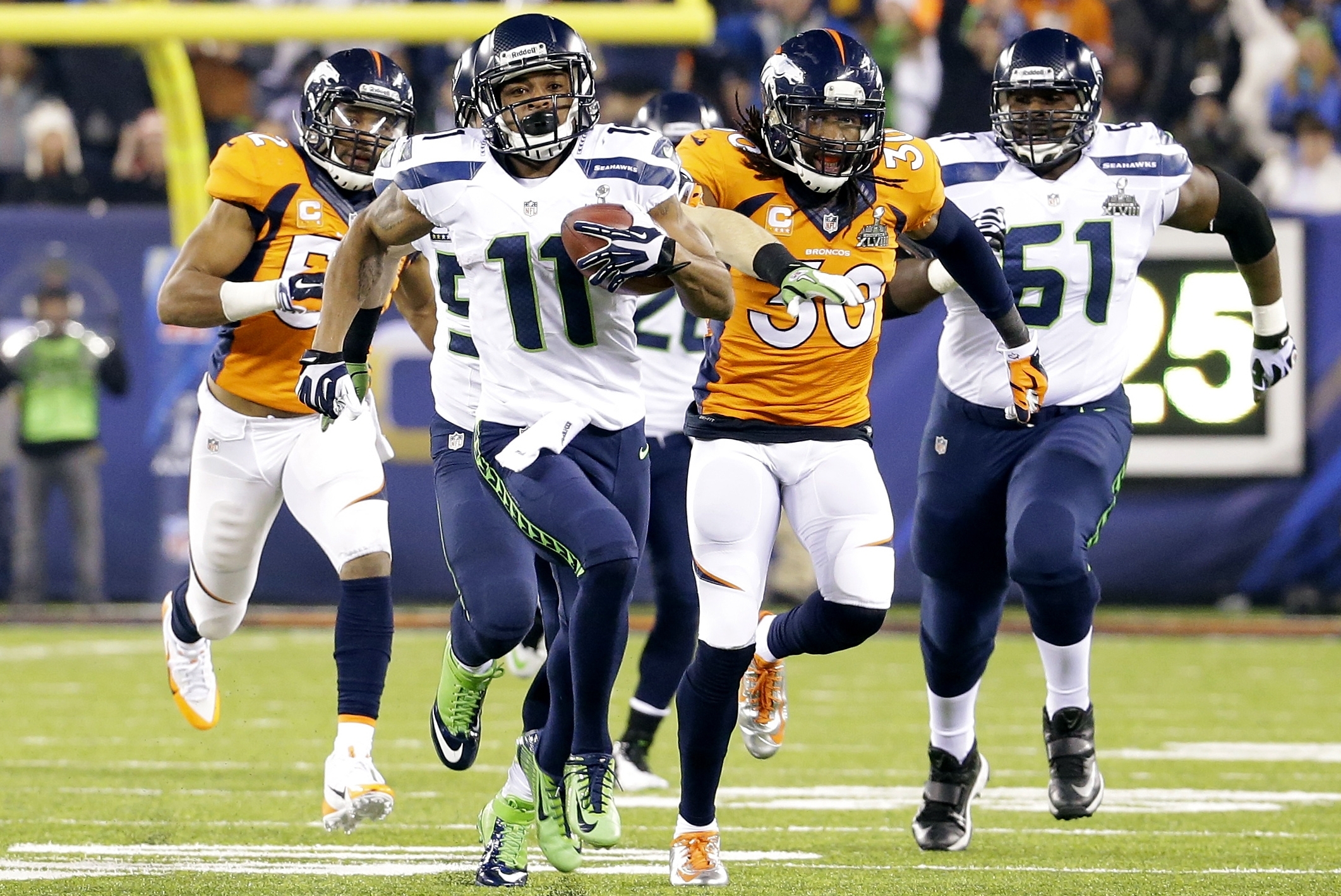 Seattle Seahawks' Percy Harvin (11) runs from Denver Broncos' David Bruton (30) while returning a kickoff 87-yards for a touchdown during the second half of the NFL Super Bowl XLVIII football game Sunday, Feb. 2, 2014, in East Rutherford, N.J.  (AP Photo/Ted S. Warren)
