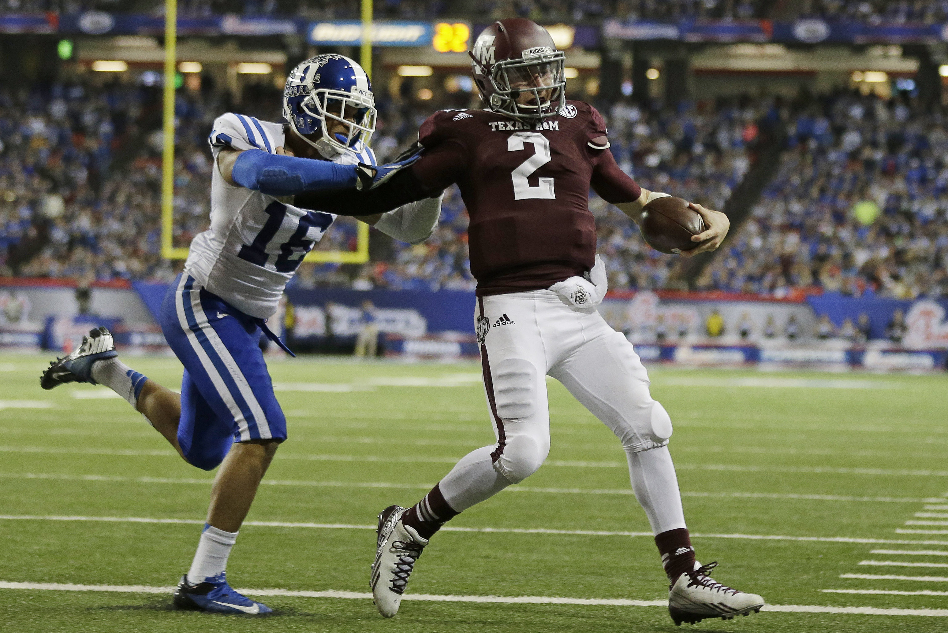 Texas A&M quarterback Johnny Manziel (2) scores a touchdown as Duke safety Jeremy Cash (16) defends in the second half of the Chick-fil-A Bowl NCAA college football game Tuesday, Dec. 31, 2013, in Atlanta. (AP Photo/John Bazemore)