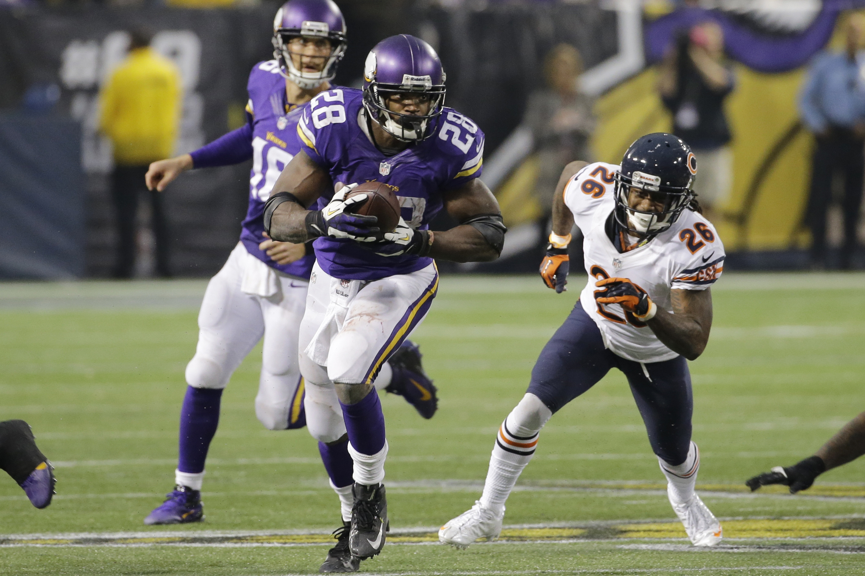 Minnesota Vikings running back Adrian Peterson (28) runs from Chicago Bears cornerback Tim Jennings (26) during overtime of an NFL football game, Sunday, Dec. 1, 2013, in Minneapolis.  The Vikings won 23-20. (AP Photo/Ann Heisenfelt)