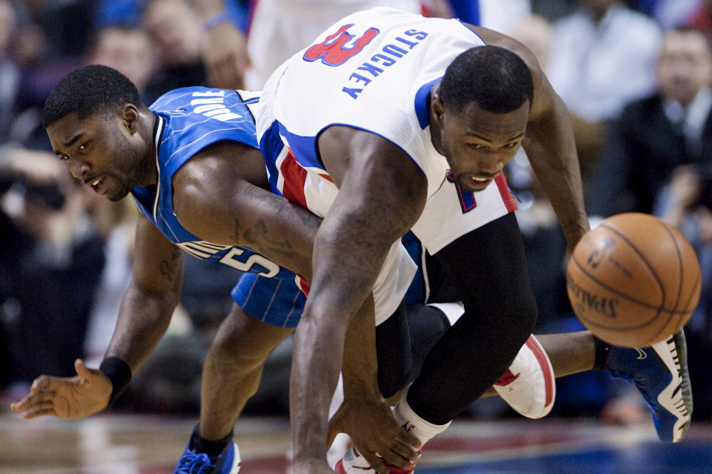 Orlando Magic guard E'Twaun Moore, left, trips up Detroit Pistons guard Rodney Stuckey (3) while chasing a loose ball during the first half of an NBA basketball game Tuesday, Jan. 28, 2014, in Auburn Hills, Mich. (AP Photo/Duane Burleson)