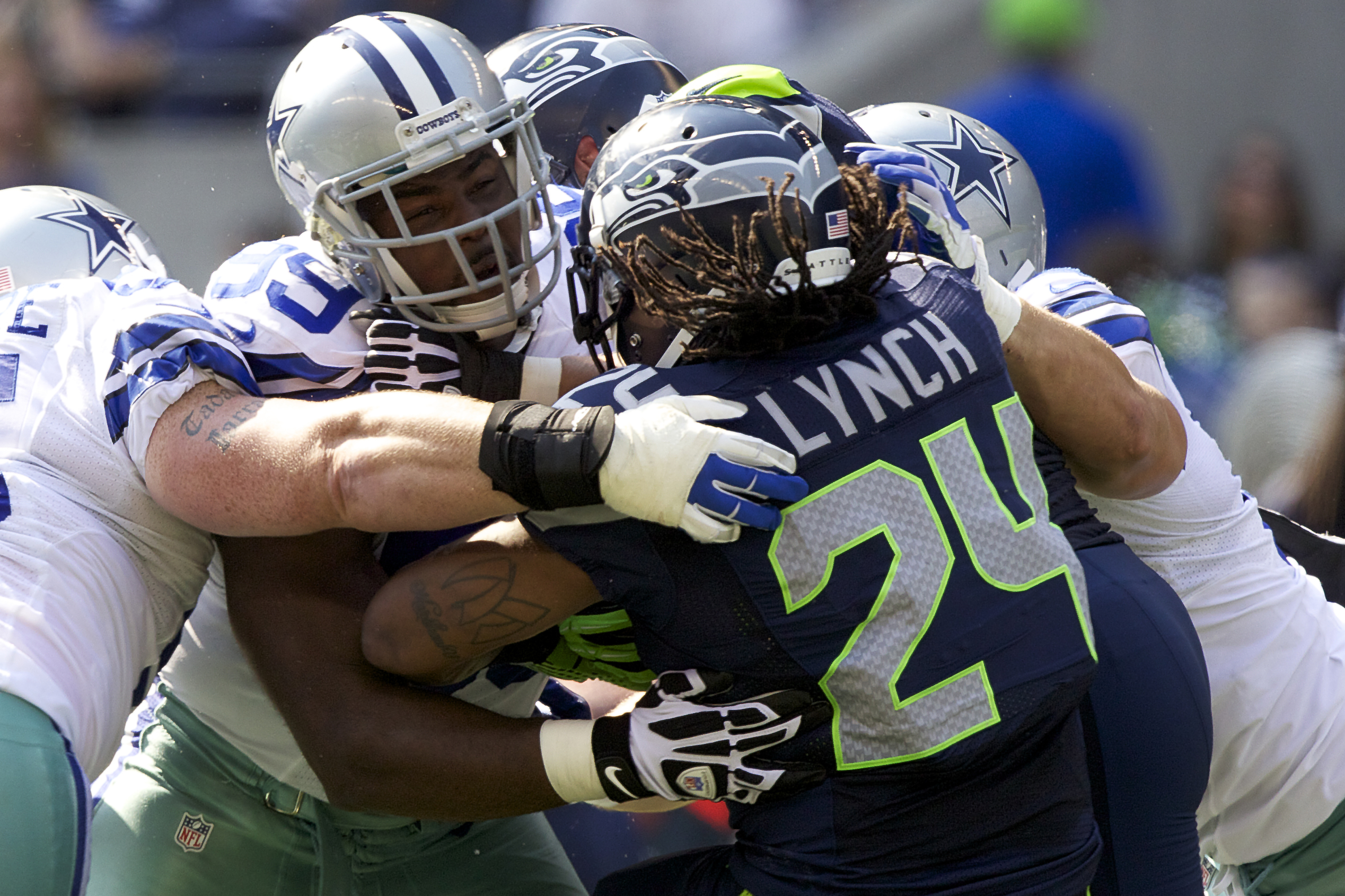 SEATTLE, WA - SEPTEMBER 16:  Kenyon Coleman #99 of the Dallas Cowboys tackles Marshawn Lynch #24 of the Seattle Seahawks during a game at CenturyLink Field on September 16, 2012 in Seattle, Washington. The Seahawks won the game 27-7.  (Photo by Stephen Brashear/Getty Images)