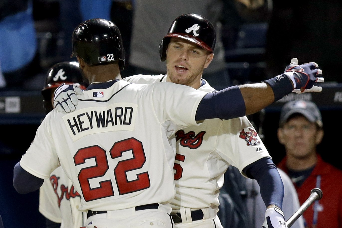 Atlanta Braves' Jason Heyward, left, is embraced by teammate Freddie Freeman after hitting a two-run home run in the ninth inning of a baseball game against the Washington Nationals, Saturday, Aug. 17, 2013, in Atlanta. (AP Photo/David Goldman)