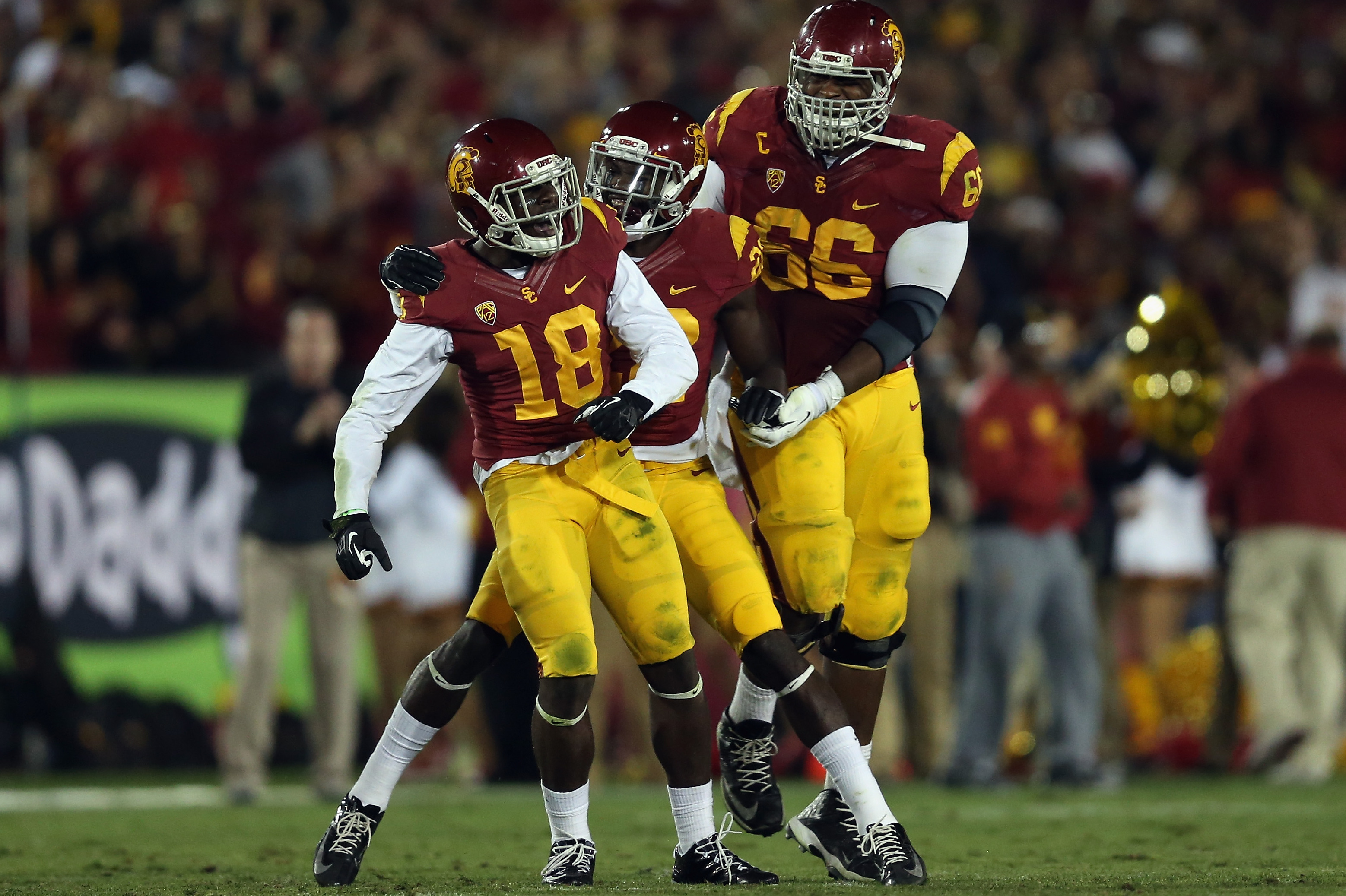LOS ANGELES, CA - NOVEMBER 16:  (L-R) Safety Dion Bailey #18 of the USC Trojans is congratulated by Leon McQuay III #22 and Marcus Martin #66 after an interception in the fourth quarter against the Stanford Cardinal at Los Angeles Coliseum on November 16, 2013 in Los Angeles, California. USC defeated Stanford 20-17.  (Photo by Jeff Gross/Getty Images)