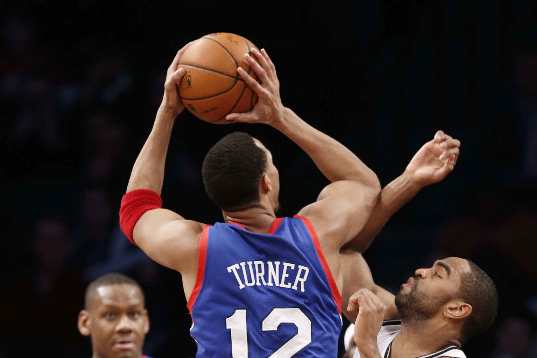 Brooklyn Nets forward Alan Anderson (6) defends Philadelphia 76ers forward Evan Turner (12) as 76ers forward Lavoy Allen (50) looks on from the floor in their NBA basketball game at the Barclays Center, Monday, Feb. 3, 2014 in New York. (AP Photo/Kathy Willens)