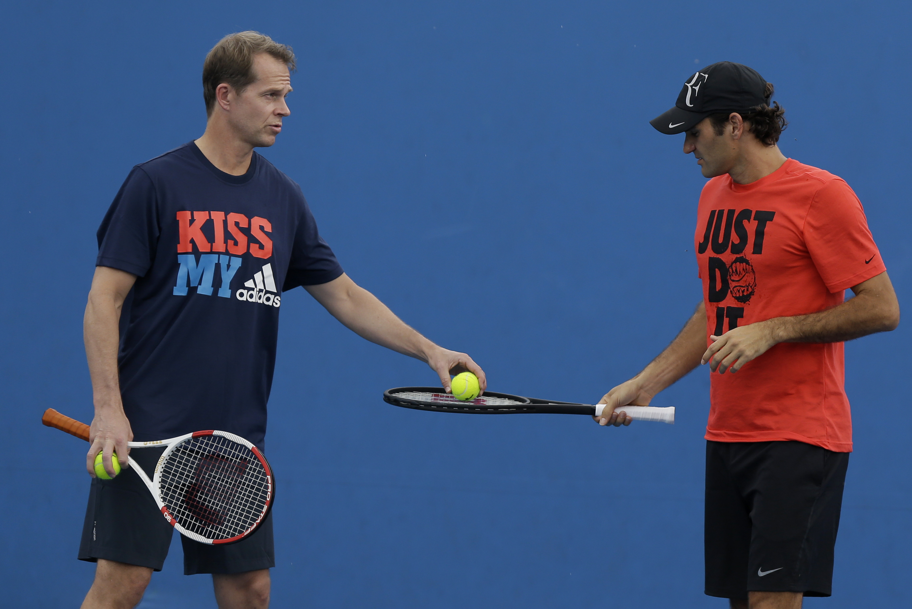 Switzerland's Roger Federer, right, chats with coach and former Grand Slam champion Stefan Edberg during a practice session at the Australian Open tennis championship in Melbourne, Australia, Wednesday, Jan. 15, 2014. (AP Photo/Mark Baker)