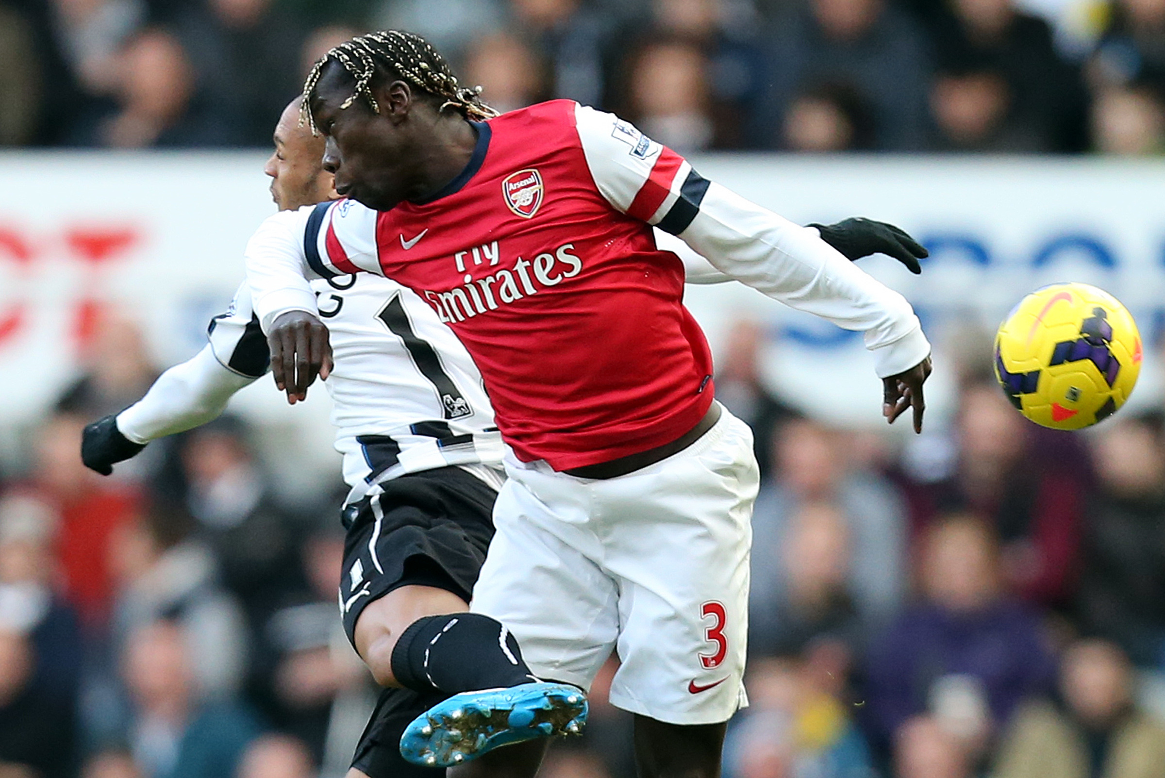 Newcastle United's Yoan Gouffran, left, vies for the ball with Arsenal's Bacray Sagna, right, during their English Premier League soccer match at St James' Park, Newcastle, England, Sunday, Dec. 29, 2013. (AP Photo/Scott Heppell)