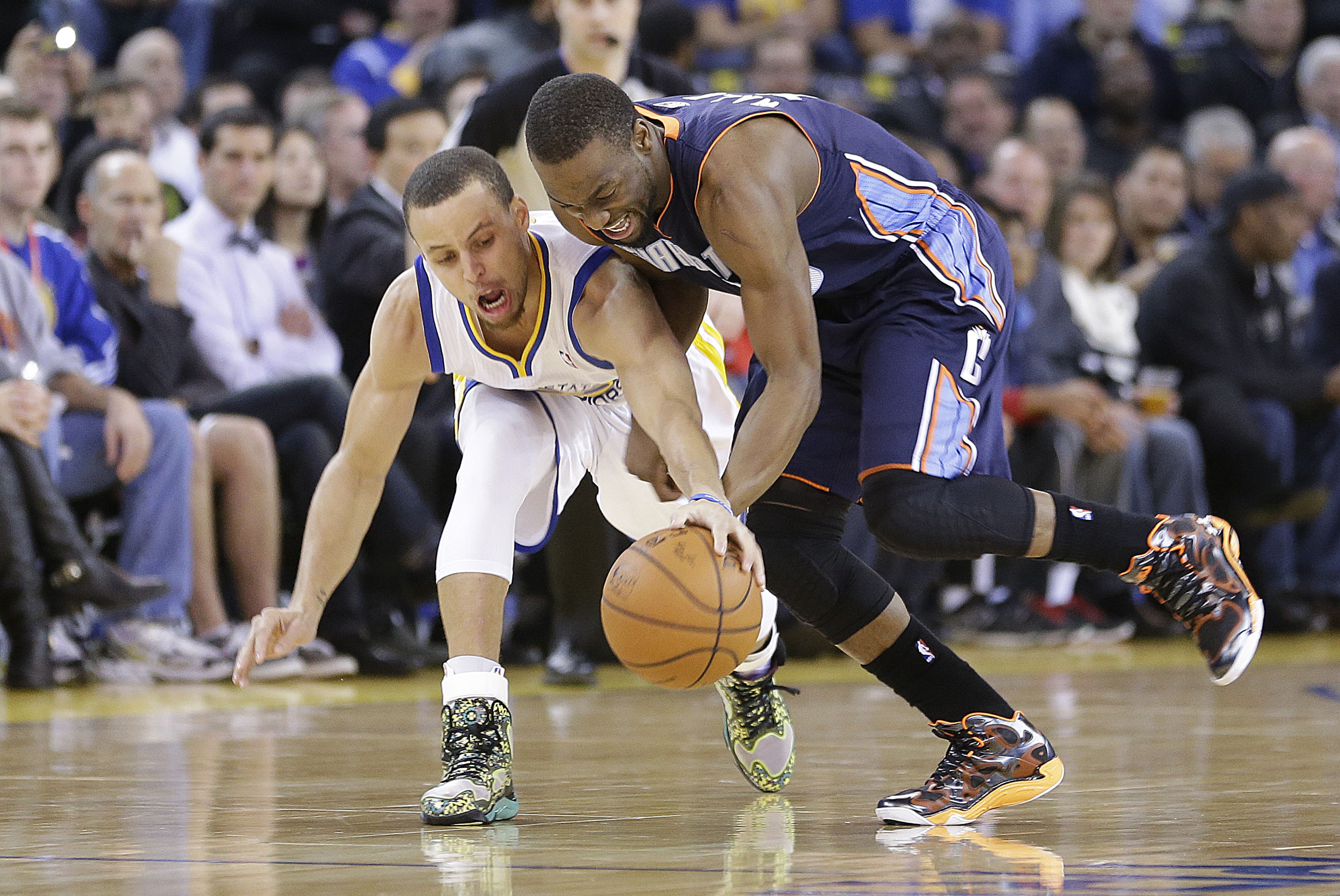 Charlotte Bobcats’ Kemba Walker (15) battles for a loose ball against Golden State Warriors’ Stephen Curry (30) during the first half of an NBA basketball game in Oakland, Calif., Tuesday, Feb. 4, 2014. (AP Photo/Tony Avelar)
