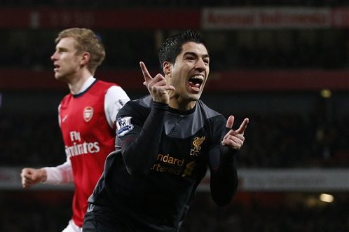 Liverpool's Luis Suarez, right, celebrates his goal as Arsenal's Per Mertesacker stands in the background during the English Premier League soccer match between Arsenal and Liverpool at the Emirates Stadium in London, Wednesday, Jan. 30, 2013. (AP Photo/Matt Dunham)
