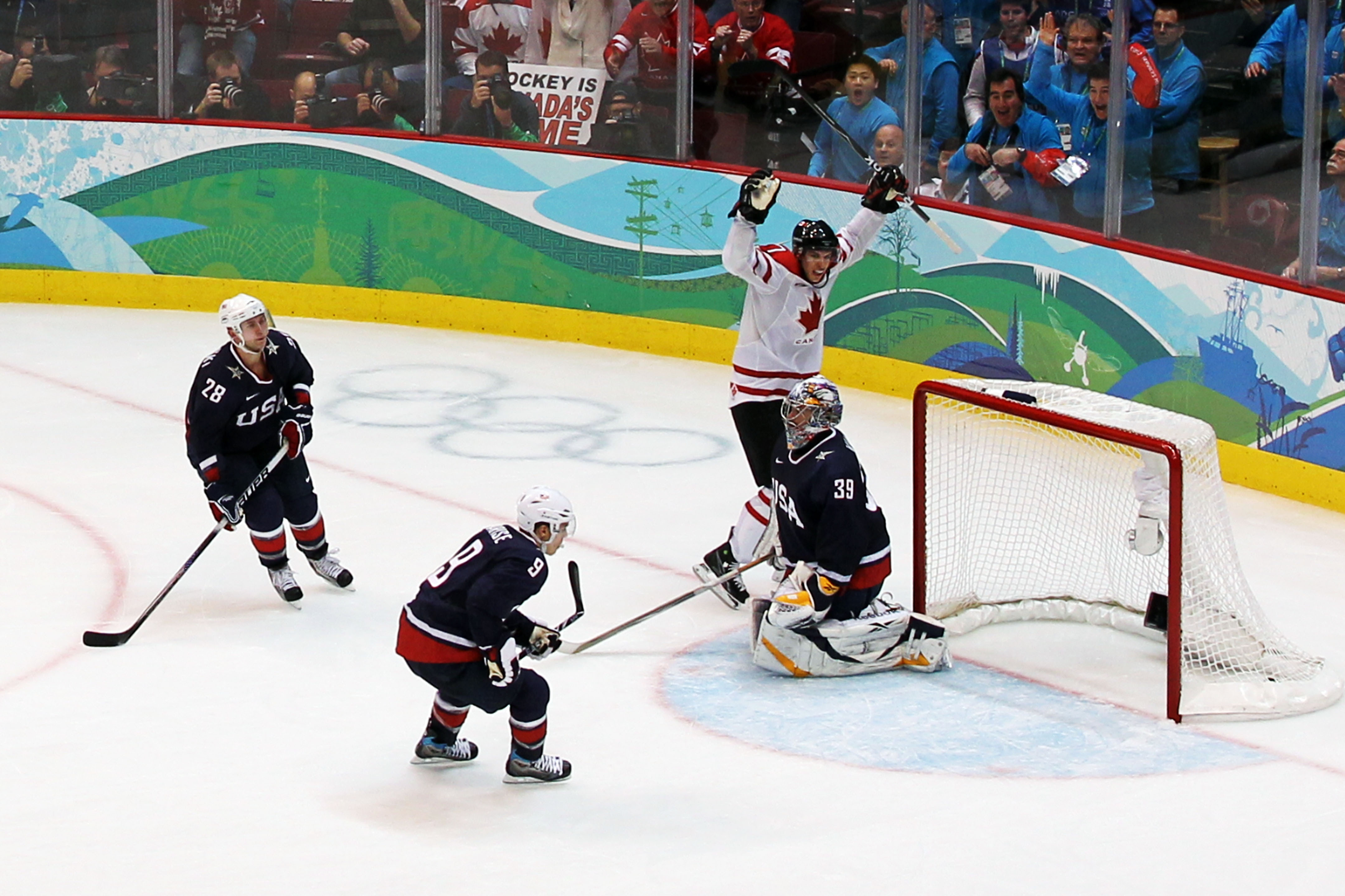 VANCOUVER, BC - FEBRUARY 28:  Sidney Crosby #87 of Canada celebrates after scoring the matchwinning goal in overtime whilst dejected Team USA players look on during the ice hockey men's gold medal game between USA and Canada on day 17 of the Vancouver 2010 Winter Olympics at Canada Hockey Place on February 28, 2010 in Vancouver, Canada.  (Photo by Jamie Squire/Getty Images)
