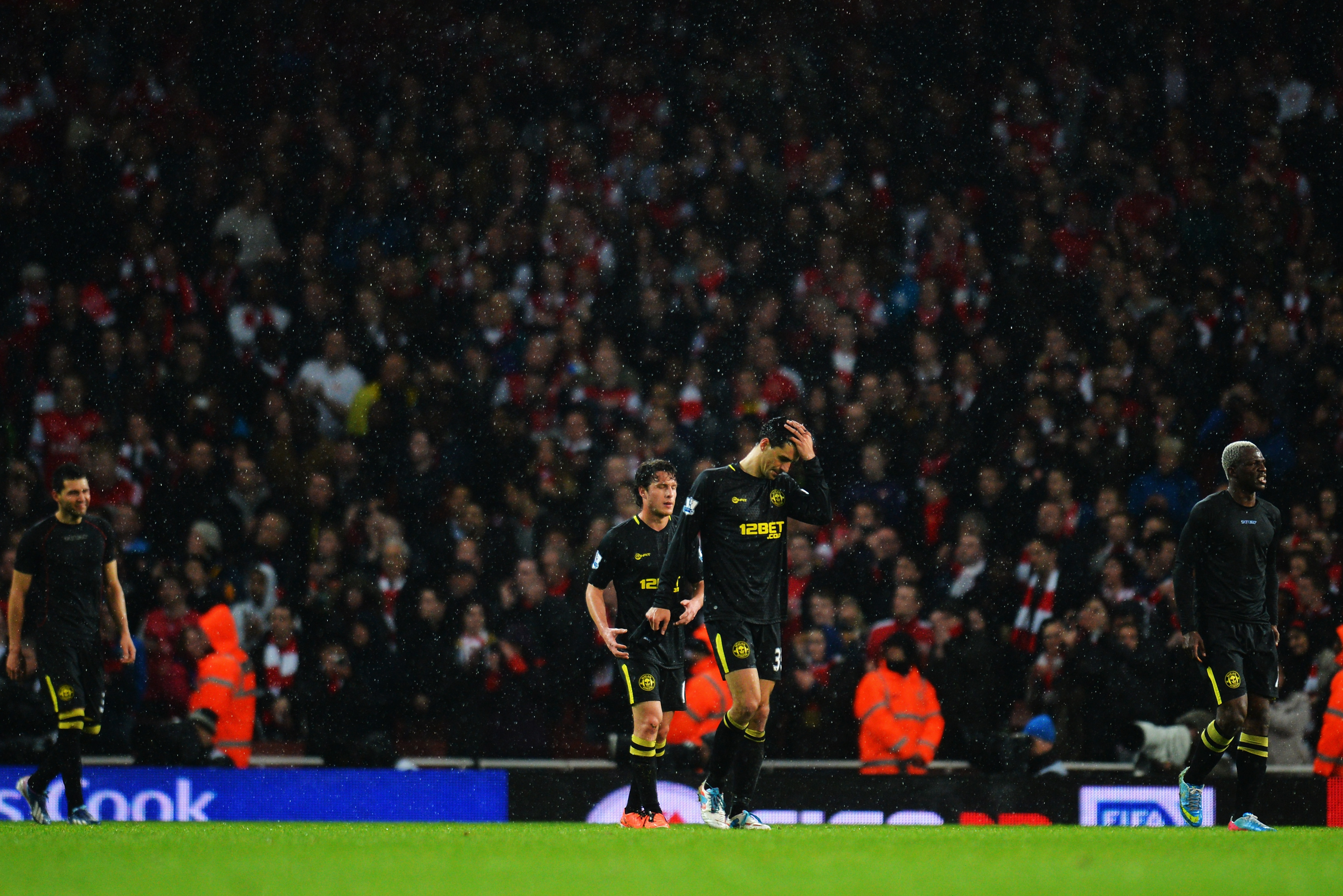 LONDON, ENGLAND - MAY 14:  Wigan Athletic players walk off dejected after being relegated following their defeat in the Barclays Premier League match between Arsenal and Wigan Athletic at Emirates Stadium on May 14, 2013 in London, England.  (Photo by Shaun Botterill/Getty Images)