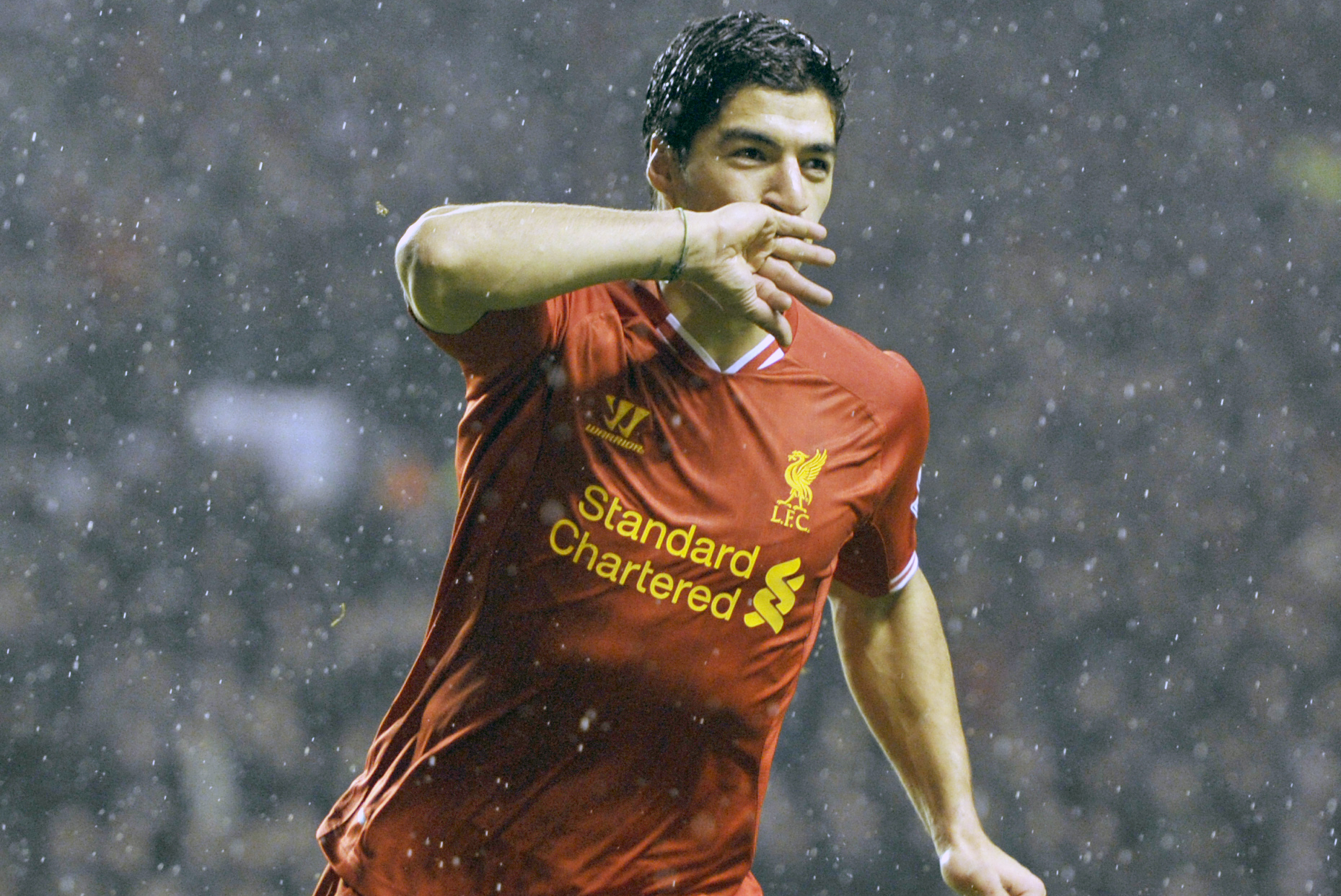 Liverpool's Luis Suarez celebrates after he scores the fourth goal of the game for his side during their English Premier League soccer match against Everton at Anfield in Liverpool, England, Tuesday Jan. 28, 2014. (AP Photo/Clint Hughes)