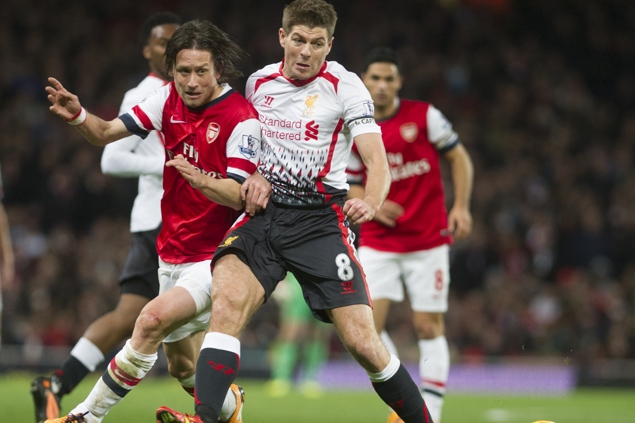 Arsenal's Laurent Koscielny  fights for the ball with Liverpool's Steven Gerrard, during their English Premier League soccer match, at the Emirates Stadium, in London, Saturday, Nov. 2, 2013. (AP Photo / Bogdan Maran)