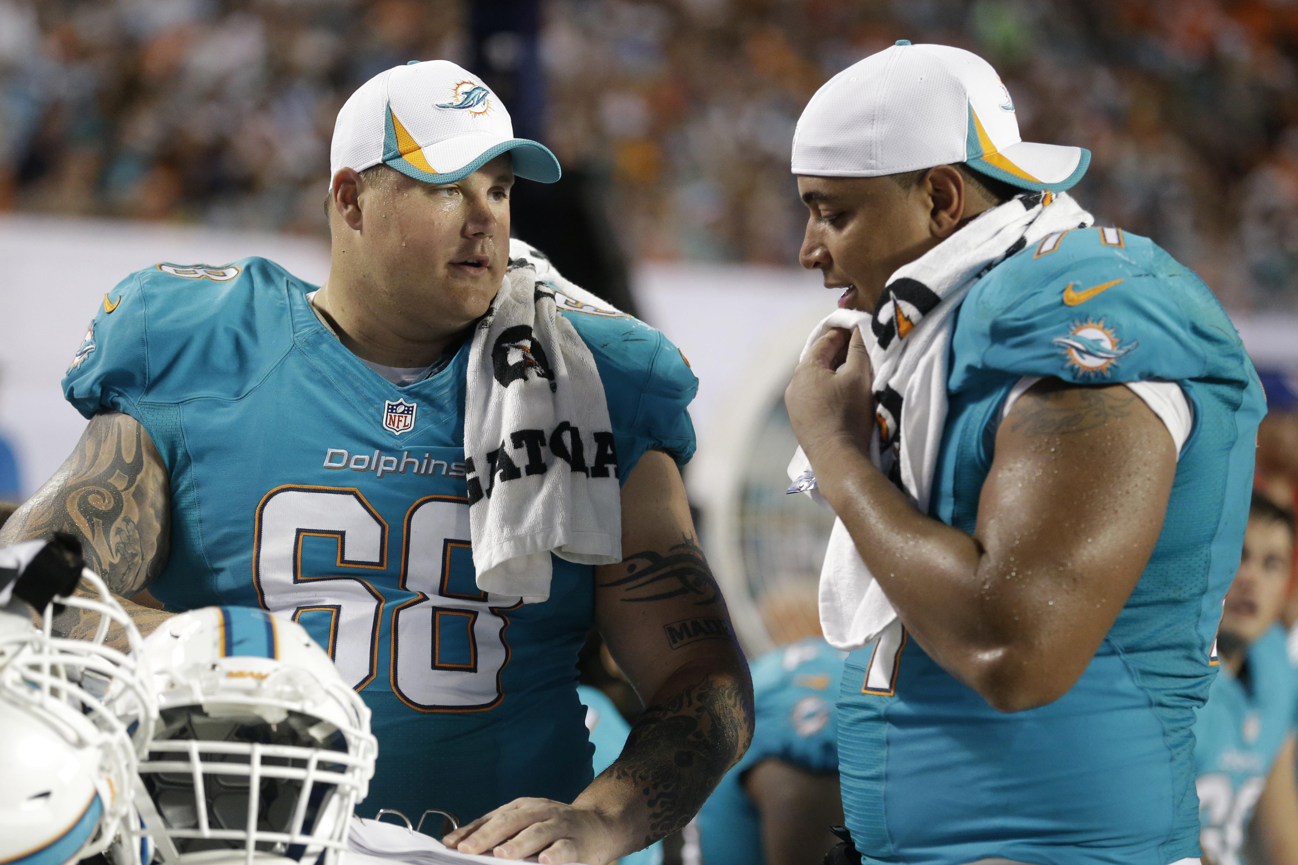 Miami Dolphins guard Richie Incognito (68) and tackle Jonathan Martin (71) looks over plays during the second half of an NFL preseason football game against the Tampa Bay Buccaneers, Saturday, Aug. 24, 2013 in Miami Gardens, Fla. (AP Photo/Wilfredo Lee)