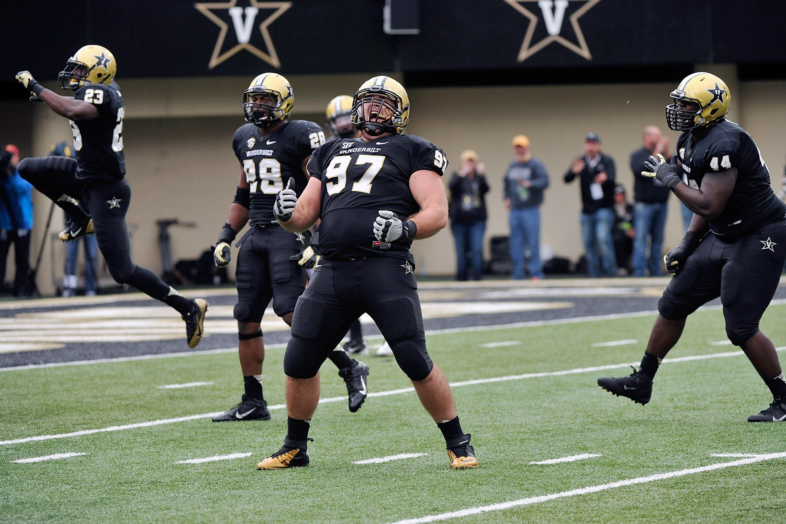 NASHVILLE, TN - OCTOBER 19:  Jared Morse #97 of the Vanderbilt Commodores celebrates a Vanderbilt fumble recovery with teammates Andre Hal #23, Barron Dixon #44, and Karl Butler #28 during a game against of the Georgia Bulldogs at Vanderbilt Stadium on October 19, 2013 in Nashville, Tennessee.  (Photo by Frederick Breedon/Getty Images)