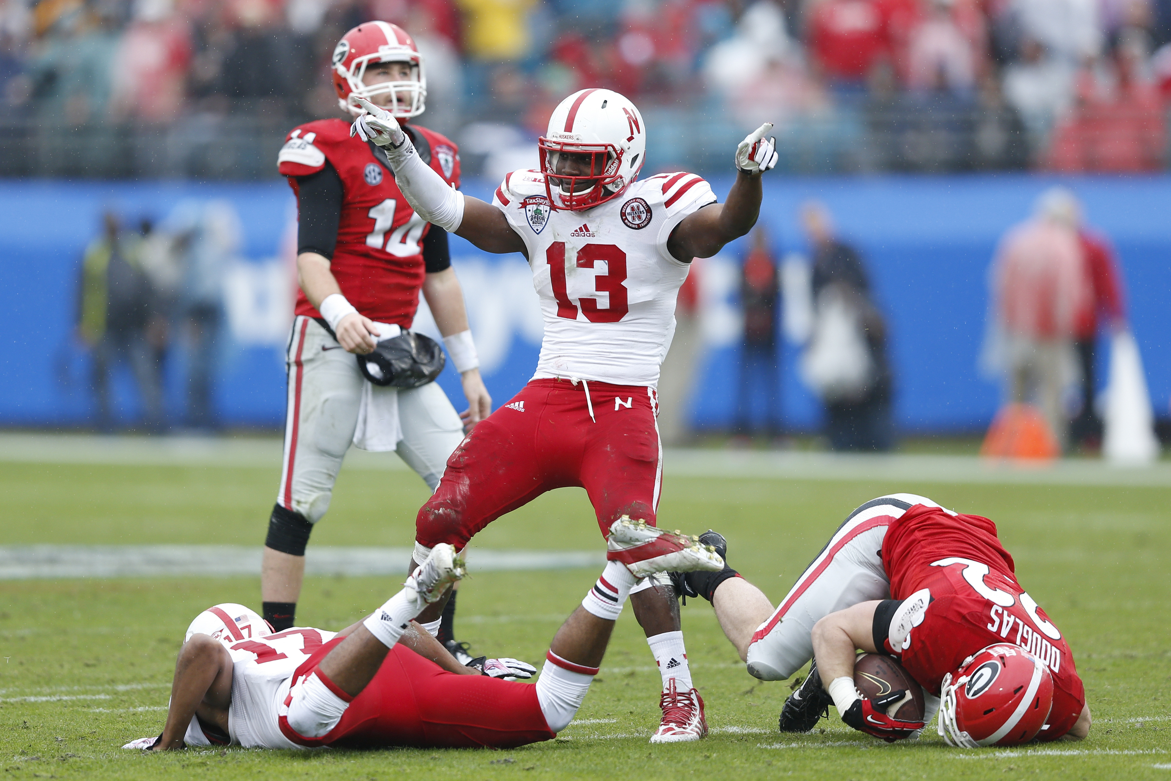 JACKSONVILLE, FL - JANUARY 1: Zaire Anderson #13 of the Nebraska Cornhuskers celebrates after tackling Brendan Douglas #22 of the Georgia Bulldogs in the first half during the TaxSlayer.com Gator Bowl at Everbank Field on January 1, 2014 in Jacksonville, Florida. (Photo by Joe Robbins/Getty Images)
