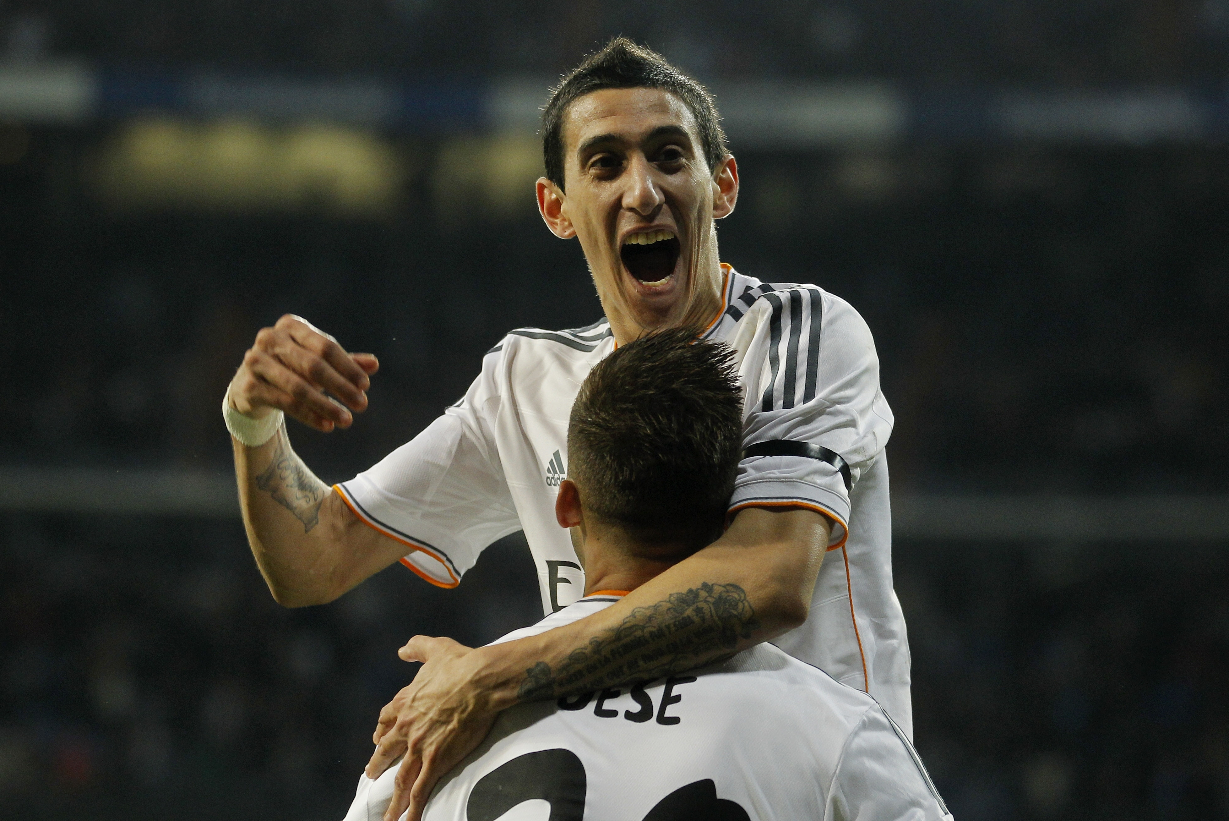 Real's Angel Di Maria, top celebrates with Real's Jese Rodriguez after Rodrigues scored during a semi final, 1st leg, Copa del Rey soccer derby match between Real Madrid and Atletico Madrid at the Santiago Bernabeu Stadium in Madrid, Wednesday Feb. 5, 2014.  (AP Photo/Paul White)
