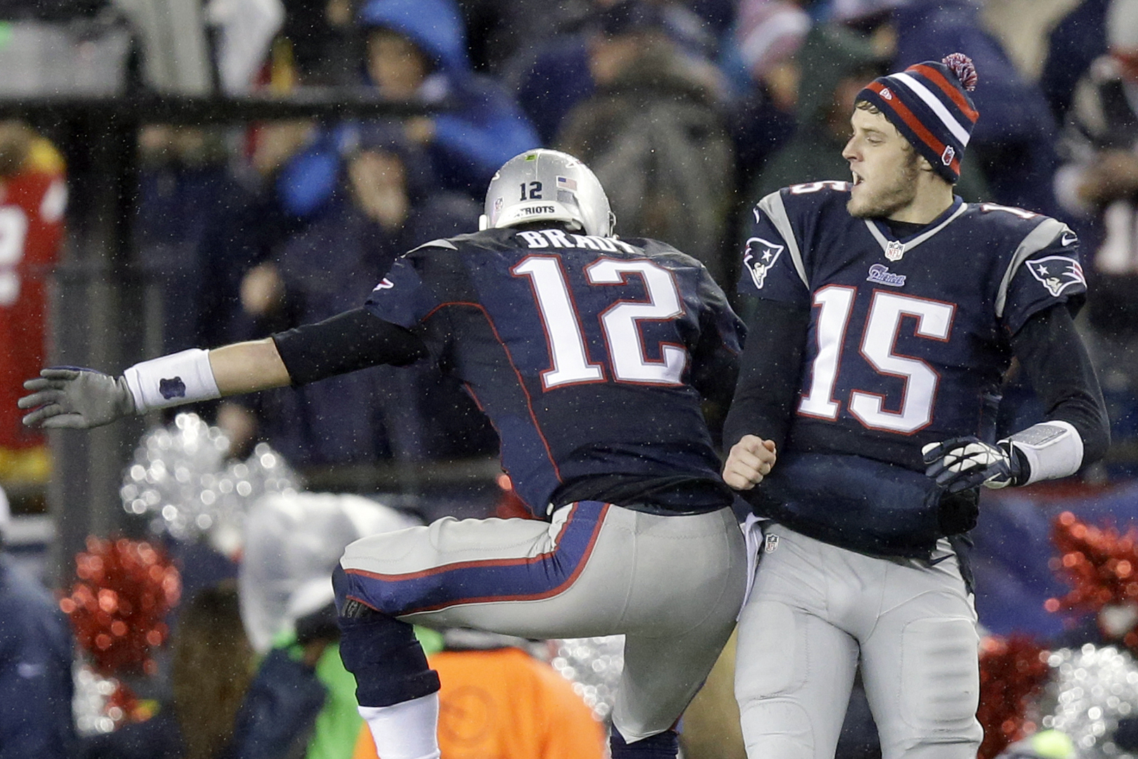 New England Patriots quarterbacks Tom Brady (12) and Ryan Mallett (15) celebrate after a touchdown against the New England Patriots in the first half of an AFC divisional NFL playoff football game in Foxborough, Mass., Saturday, Jan. 11, 2014. (AP Photo/Stephan Savoia)