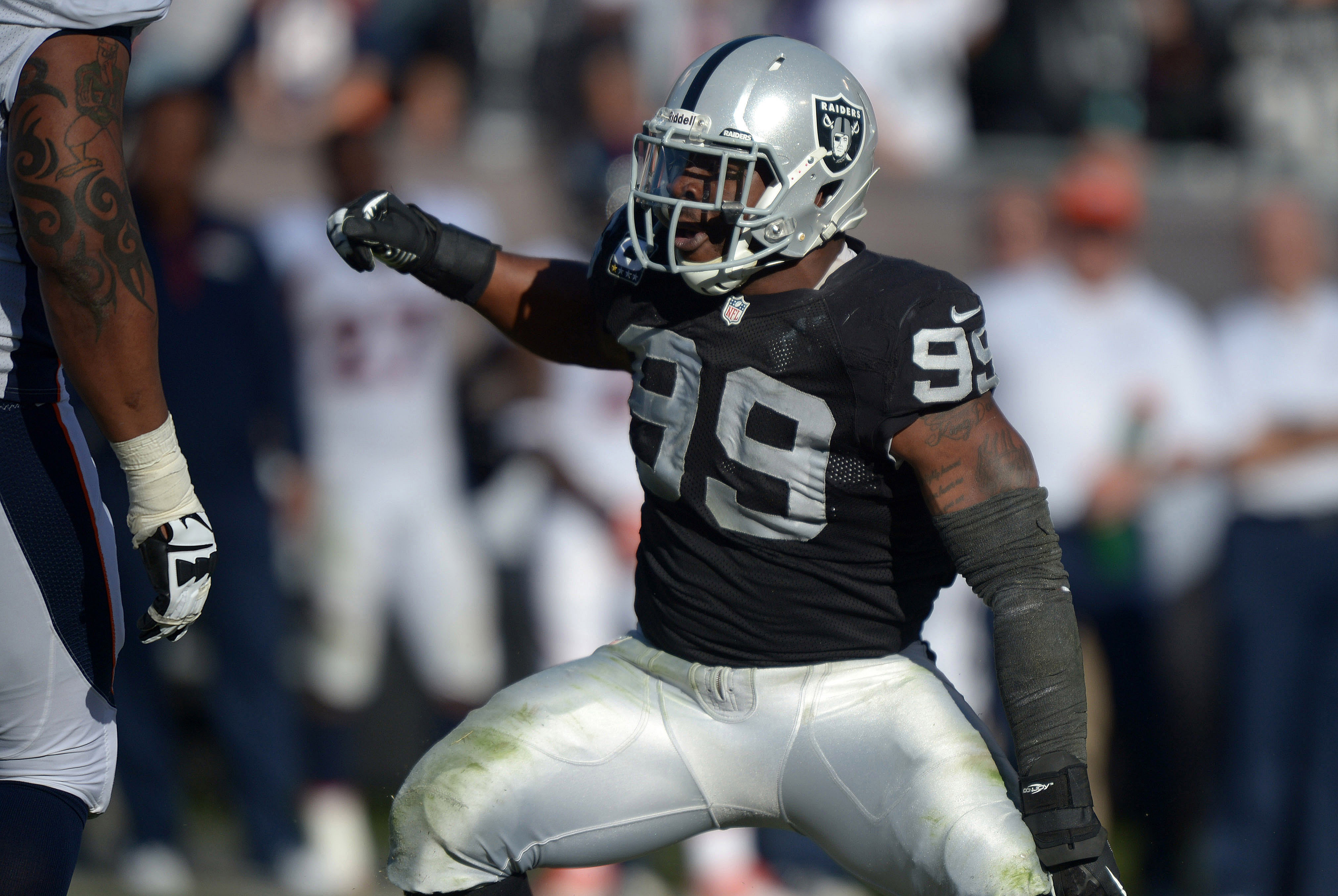 Dec 29, 2013; Oakland, CA, USA; Oakland Raiders defensive end Lamarr Houston (99) reacts during the game against the Denver Broncos at O.co Coliseum. The Broncos won 34-14. Mandatory Credit: Kirby Lee-USA TODAY Sports