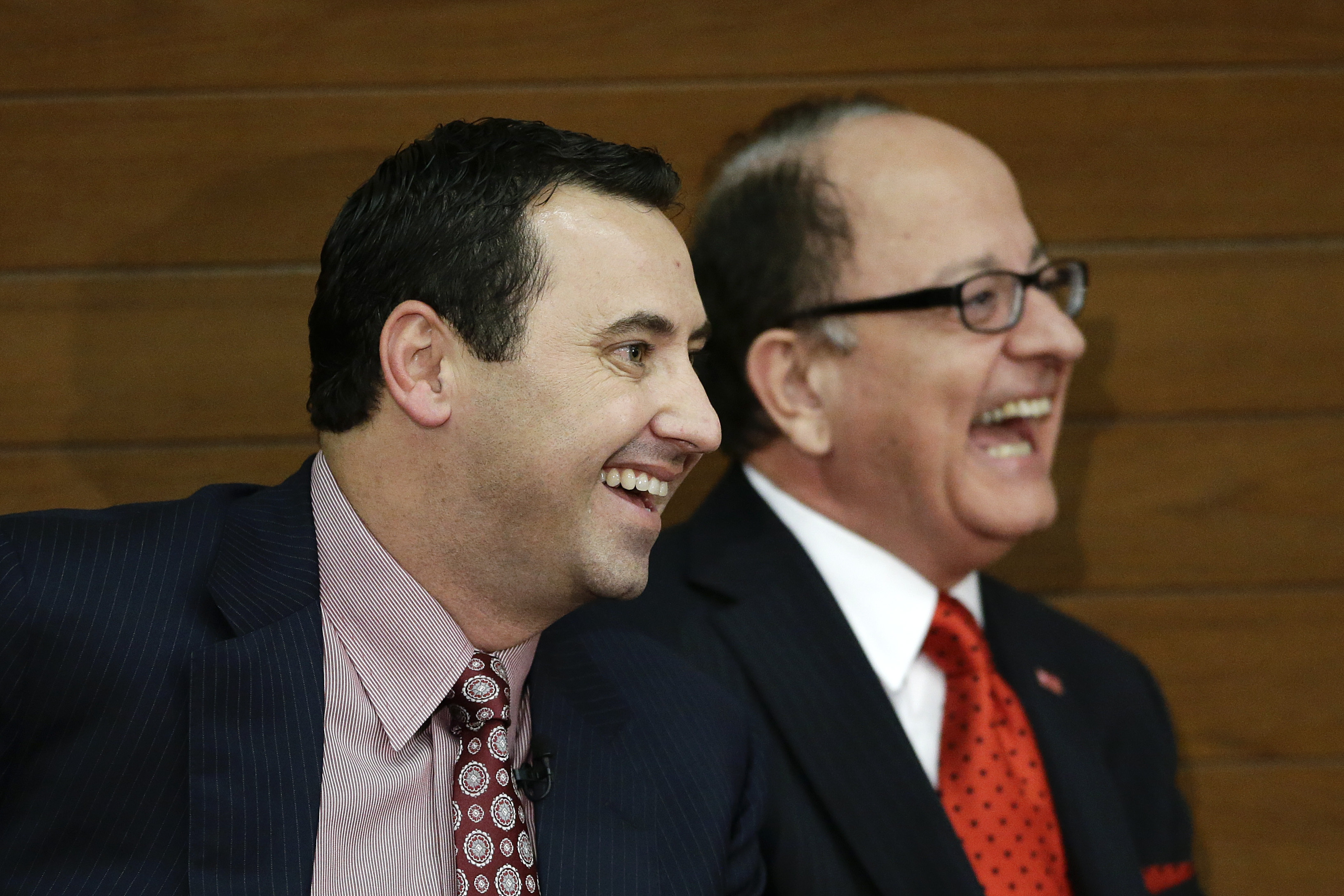 New Southern California football head coach Steve Sarkisian, left, and USC president, C. L. Max Nikias laugh during a news conference on Tuesday, Dec. 3, 2013, in Los Angeles. USC hired Sarkisian away from Washington on Monday, bringing back the former Trojans offensive coordinator to his native Los Angeles area and the storied program where he thrived as Pete Carroll's assistant. (AP Photo/Jae C. Hong)