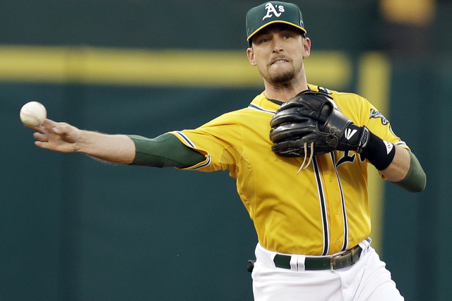 Oakland Athletics shortstop Jed Lowrie throws out Detroit Tigers Torii Hunter in the first inning of Game 2 of an American League  baseball division series in Oakland, Calif., Saturday, Oct. 5, 2013. (AP Photo/Ben Margot)