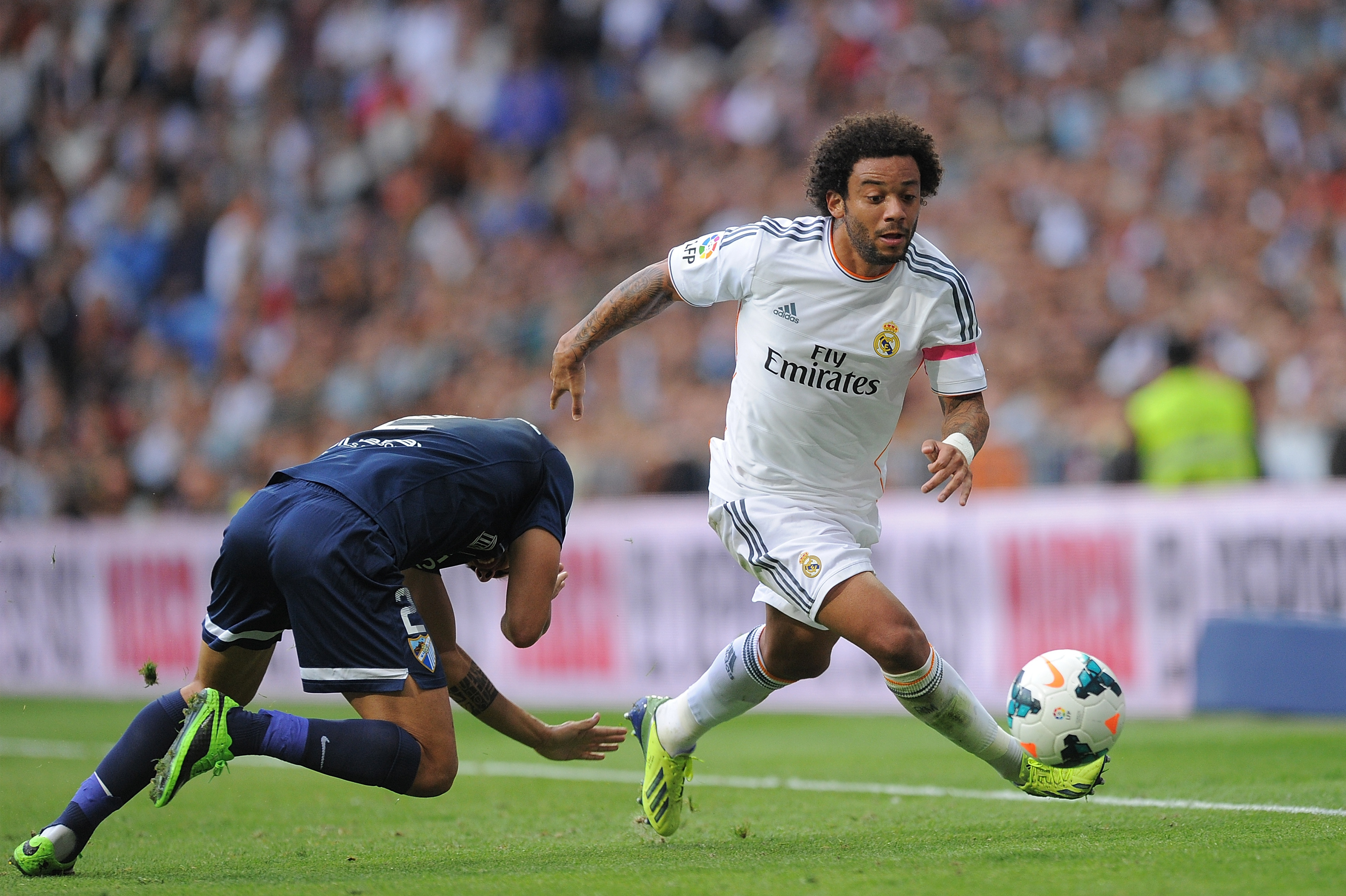 MADRID, SPAIN - OCTOBER 19:  Marcelo (R) of Real Madrid CF beats Jesus Gamez of Malaga CF during the La Liga match between Real Madrid CF and Malaga CF at the Santiago Bernabeu stadium on October 19, 2013 in Madrid, Spain.  (Photo by Denis Doyle/Getty Images)