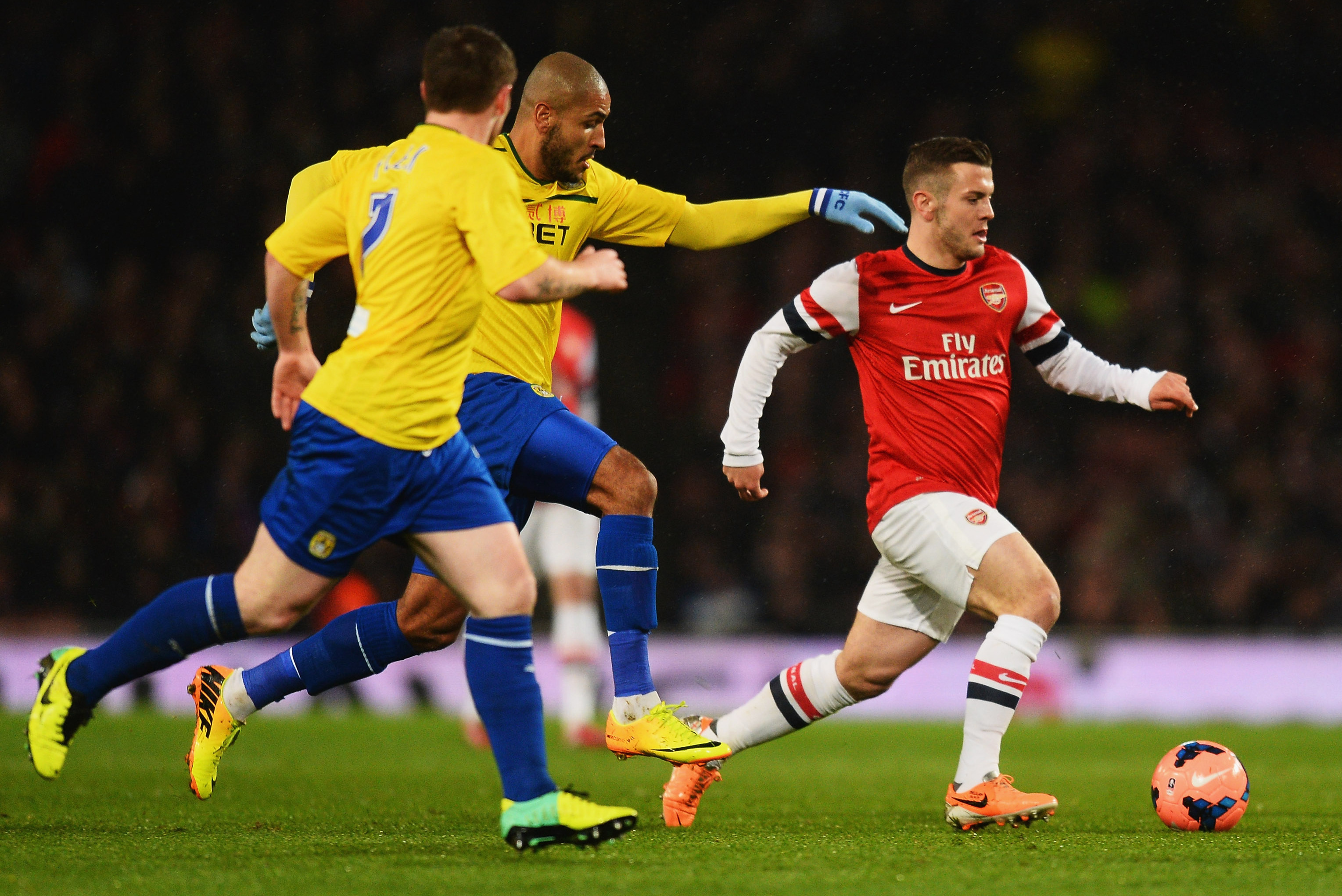 LONDON, ENGLAND - JANUARY 24:  Jack Wilshere of Arsenal is chased by Leon Clarke of Coventry City during the FA Cup with Budweiser Fourth round match between Arsenal and Coventry City at Emirates Stadium on January 24, 2014 in London, England.  (Photo by Mike Hewitt/Getty Images)