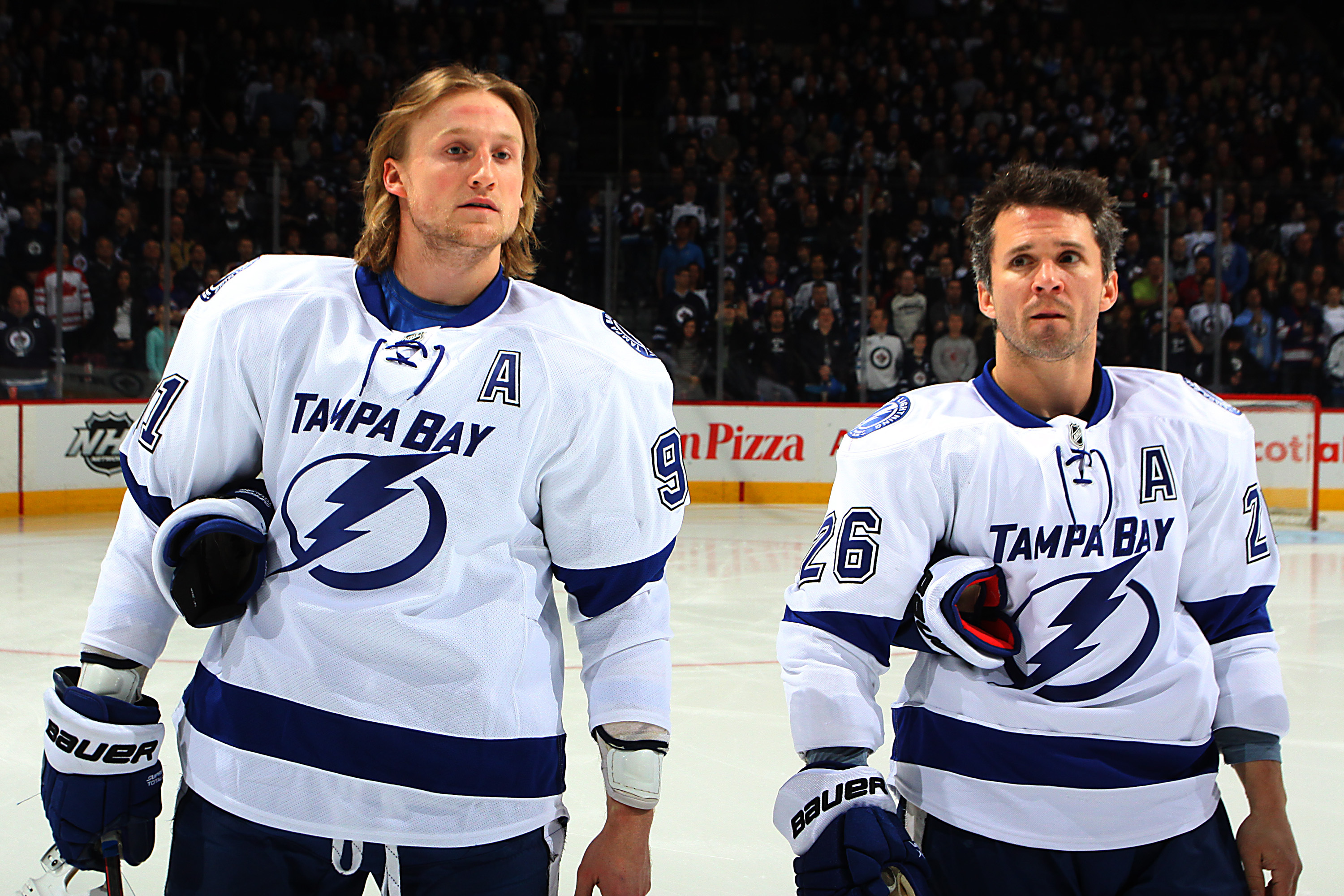 WINNIPEG, CANADA - FEBRUARY 23: Steven Stamkos #91 and Martin St. Louis #26 of the Tampa Bay Lightning stand together for the National anthems prior to facing the Winnipeg Jets at the MTS Centre on February 23, 2012 in Winnipeg, Manitoba, Canada. (Photo by Jonathan Kozub/NHLI via Getty Images)