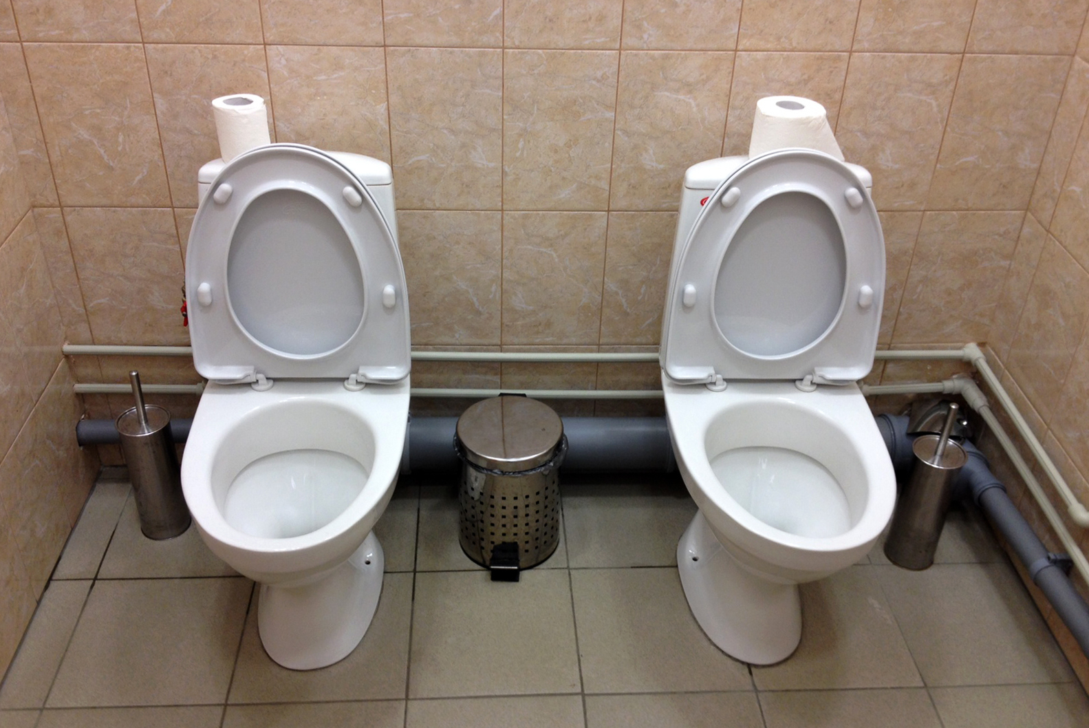 In this photo taken Saturday, Feb. 1, 2014, two female toilets sit side-by-side at the security screening facility outside the Main Press Center at the 2014 Winter Olympics, in Sochi, Russia. Side-by-side toilets in a single bathroom caused a social media sensation last month when they were discovered at the biathlon course of the Sochi Olympics, swiftly becoming a national joke in Russia. The Sochi organizing committee initially denied knowledge of the second twin toilet, and it has not been able to say whether the loo-loo was built by design or resulted from an error during the plumbing process. (AP Photo)