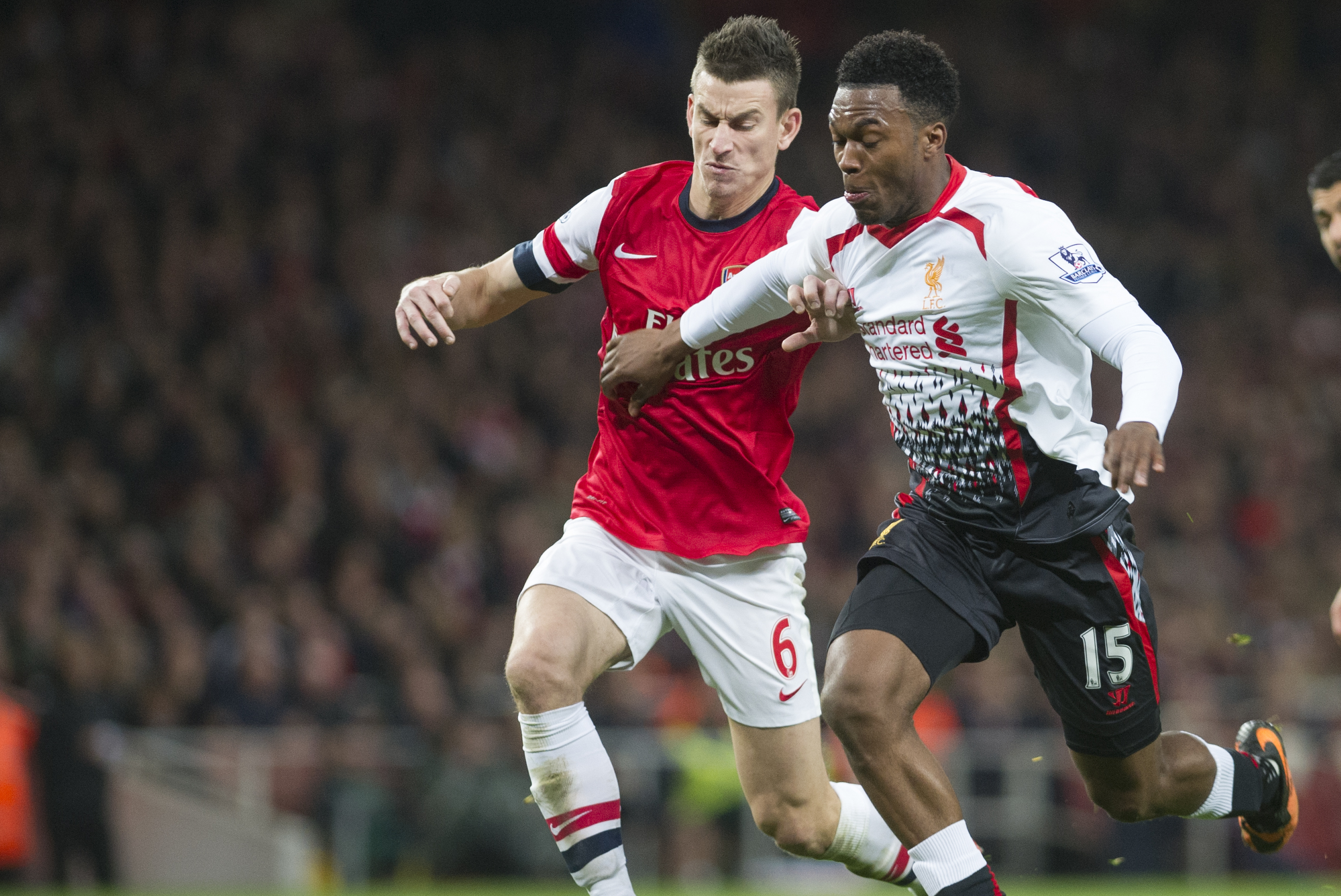 Arsenal's Daniel Sturridge fights for the ball with Liverpool's Laurent Koscielny, during their English Premier League soccer match, at the Emirates Stadium, in London, Saturday, Nov. 2, 2013. (AP Photo/Bogdan Maran)