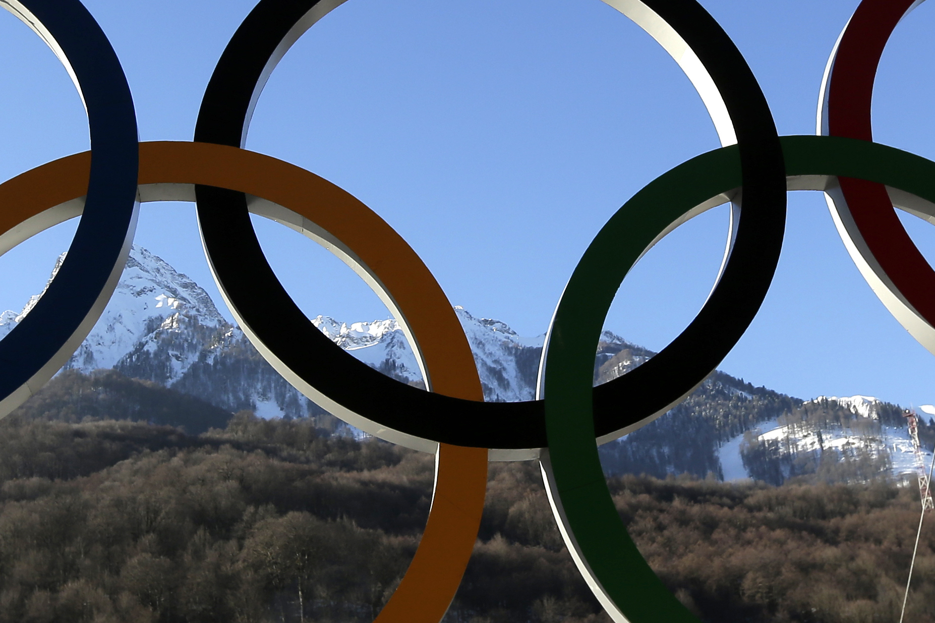 The Caucasus Mountains rise beyond a set of Olympic Rings Thursday, Feb. 6, 2014, in Rosa Khutor, Russia. The area will host the alpine events at the 2014 Winter Olympics which opens Friday, Feb. 7. (AP Photo/Charlie Riedel)