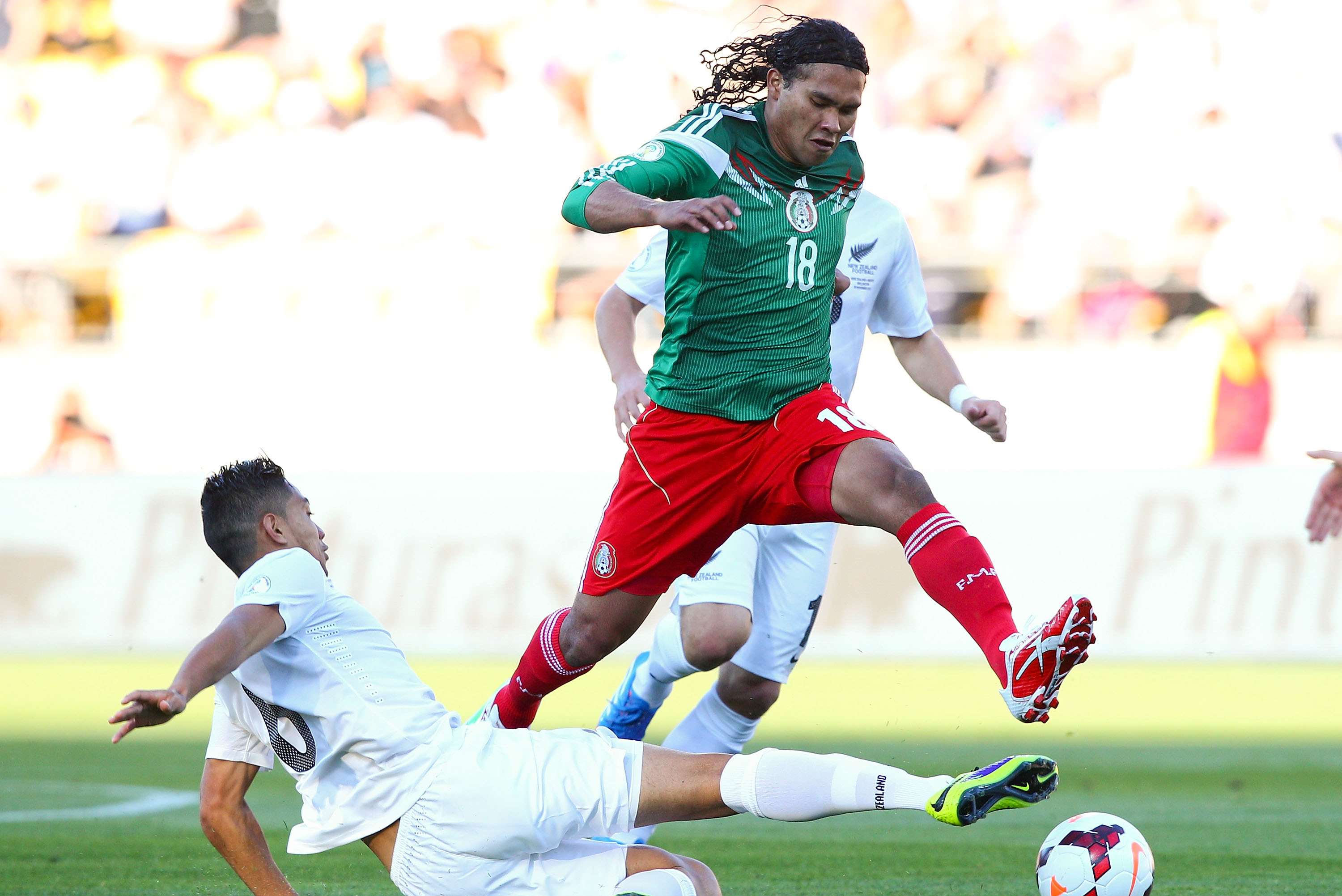 WELLINGTON, NEW ZEALAND - NOVEMBER 20:  Carlos Pena of Mexico evades the tackle of Bill Tuiloma of New Zealand during leg 2 of the FIFA World Cup Qualifier match between the New Zealand All Whites and Mexico at Westpac Stadium on November 20, 2013 in Wellington, New Zealand.  (Photo by Hagen Hopkins/Getty Images)