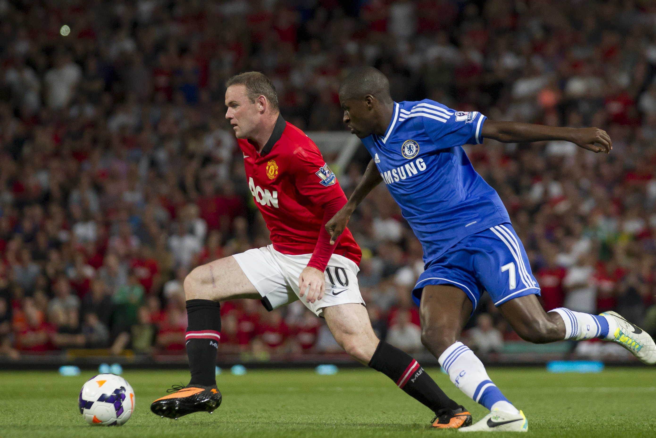 Manchester United's Wayne Rooney, left, keeps the ball from Chelsea's Ramires during their English Premier League soccer match at Old Trafford Stadium, Manchester, England, Monday Aug. 26, 2013. (AP Photo/Jon Super)