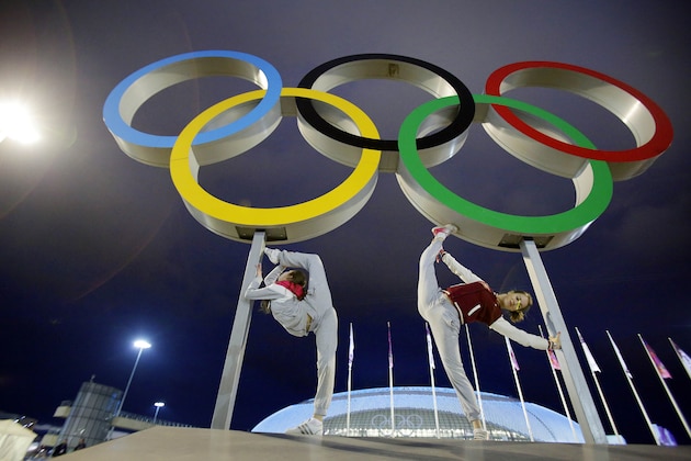 Russian dancers who will be performing at the opening ceremony pose with the Olympic rings as their friend photographs them, ahead of the 2014 Winter Olympics, Thursday, Feb. 6, 2014, in Sochi, Russia. (AP Photo/Wong Maye-E)