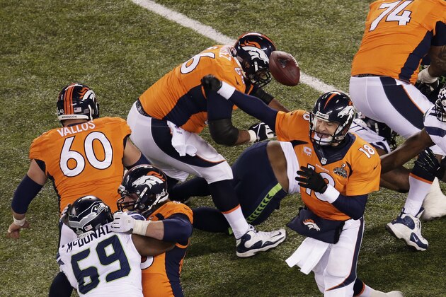 EAST RUTHERFORD, NJ - FEBRUARY 02:  Quarterback Peyton Manning #18 of the Denver Broncos has a pass blocked by the Seattle Seahawks during Super Bowl XLVIII at MetLife Stadium on February 2, 2014 in East Rutherford, New Jersey.  (Photo by Win McNamee/Getty Images)