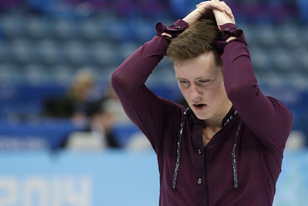 Jeremy Abbott of the United States holds his head as he skates off the ice following the men's team short program figure skating competition at the Iceberg Skating Palace during the 2014 Winter Olympics, Thursday, Feb. 6, 2014, in Sochi, Russia. (AP Photo/Darron Cummings, Pool)