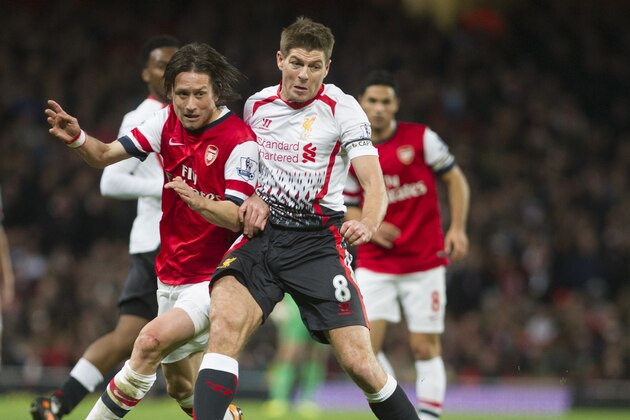 Arsenal's Laurent Koscielny  fights for the ball with Liverpool's Steven Gerrard, during their English Premier League soccer match, at the Emirates Stadium, in London, Saturday, Nov. 2, 2013. (AP Photo / Bogdan Maran)