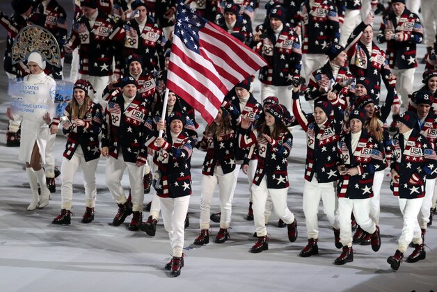 Todd Lodwick of the United States carries his country flag as the team arrives during the opening ceremony of the 2014 Winter Olympics in Sochi, Russia, Friday, Feb. 7, 2014. (AP Photo/Ivan Sekretarev)