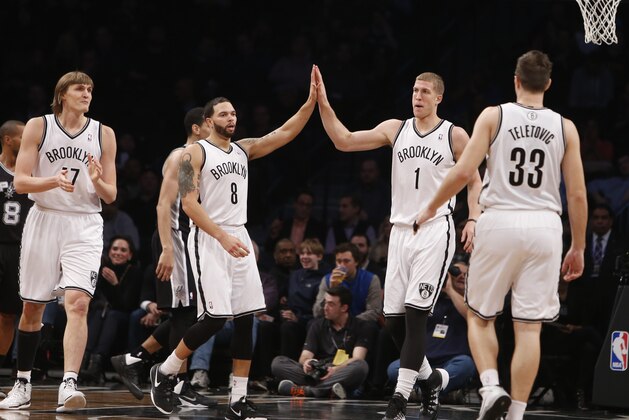 Brooklyn Nets' Deron Williams (8) congratulates teammate Mason Plumlee (1) during the first half of an NBA basketball game against the San Antonio Spurs Thursday, Feb. 6, 2014, in New York.  Brooklyn won 103-89. (AP Photo/Jason DeCrow)