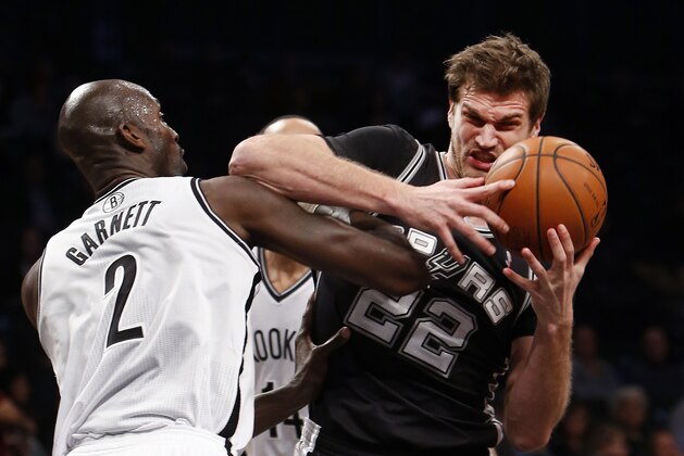 San Antonio Spurs' Tiago Splitter (22), of Brazil, is fouled by Brooklyn Nets' Kevin Garnett (2) during the first half of an NBA basketball game on Thursday, Feb. 6, 2014, in New York. (AP Photo/Jason DeCrow)