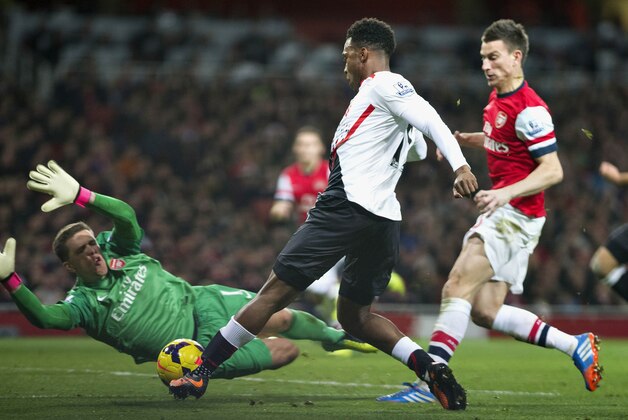 Liverpool's Daniel Sturridge tries to score against Arsenal's Laurent Koscielny, right, and Wojciech Szczesny, left,  during their English Premier League soccer match, at the Emirates Stadium, in London, Saturday, Nov. 2, 2013. (AP Photo/Bogdan Maran)