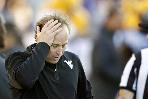 West Virginia coach Dana Holgorsen holds his head during the second half of an NCAA college football game against Kansas State in Manhattan, Kan., Saturday, Oct. 26, 2013. Kansas State won 35-12. (AP Photo/Orlin Wagner)