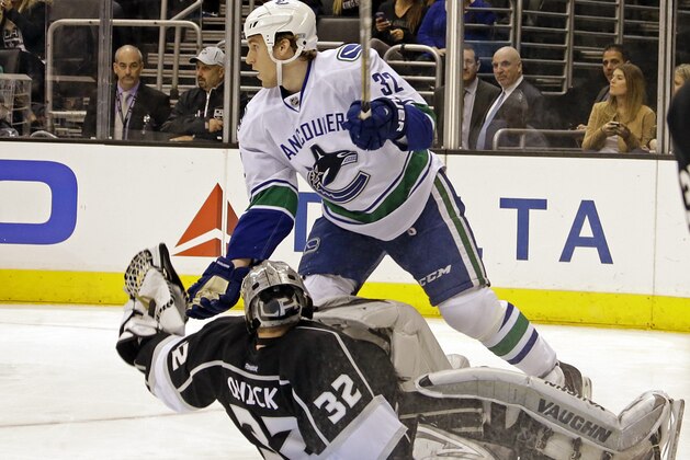 Vancouver Canucks right winger Dale Weise (32) is called for goaltender interference after colliding with Los Angeles Kings goalie Jonathan Quick (32) in the third period of an NHL hockey game in Los Angeles Monday, Jan. 13, 2014.  The Kings won, 1-0. (AP Photo/Reed Saxon)