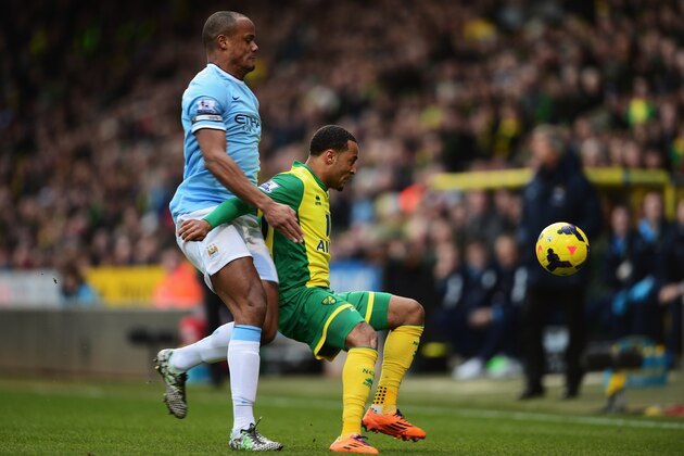NORWICH, ENGLAND - FEBRUARY 08:  Nathan Redmond (R) of Norwich City holds off the challenge of Vincent Kompany (L) of Manchester City during the Barclays Premier League match between Norwich City and Manchester City at Carrow Road on February 8, 2014 in Norwich, England.  (Photo by Jamie McDonald/Getty Images)