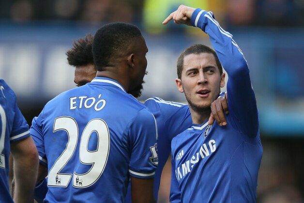 Chelsea's Eden Hazard, right, celebrates after scoring the opening goal and points towards teammate Samuel Eto'o who provided the assist during their English Premier League soccer match between Chelsea and Newcastle United in London Saturday, Feb 8  2014. (AP Photo/Alastair Grant)