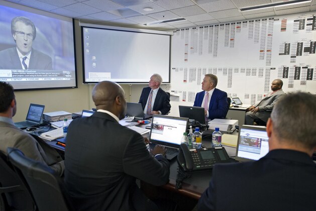 This photo provided by the Denver Broncos shows head coach John Fox, back left, and vice president John Elway, center facing camera, in the