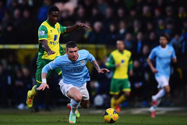 NORWICH, ENGLAND - FEBRUARY 08:  Alexander Tettey of Norwich City tackles Aleksandar Kolarov of Manchester City from behind during the Barclays Premier League match between Norwich City and Manchester City at Carrow Road on February 8, 2014 in Norwich, England.  (Photo by Jamie McDonald/Getty Images)
