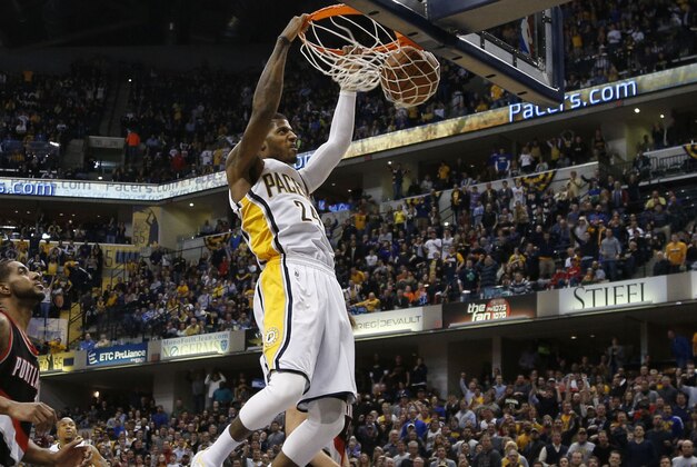 Feb 7, 2014; Indianapolis, IN, USA; Indiana Pacers forward Paul George (24) dunks against Portland Trail Blazers forward LaMarcus Aldridge (12) at Bankers Life Fieldhouse. Indiana defeats Portland 118-113 in overtime. Mandatory Credit: Brian Spurlock-USA TODAY Sports